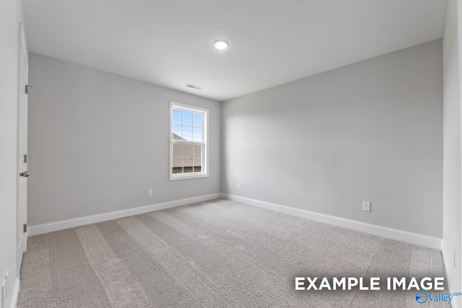 Bright secondary bedroom featuring gray walls, plush carpet, large window, and recessed lighting in Davidson Homes The Madison A, Meridianville, Alabama