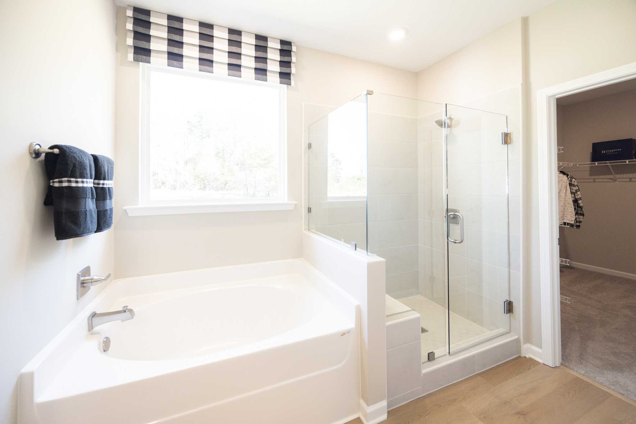 Spacious master bathroom in Silver Oak Cusseta Alabama with white tub glass shower checkered valance by Evermore Homes