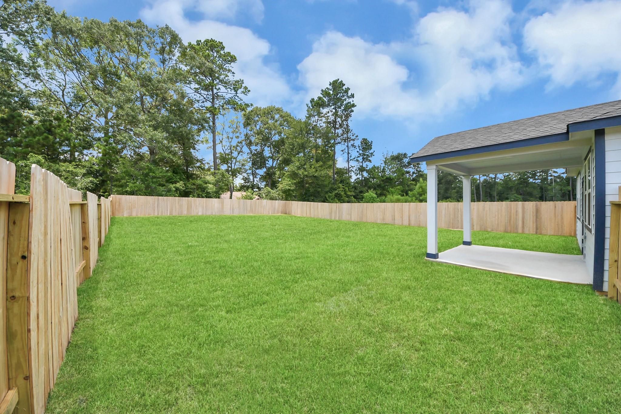 Large private fenced backyard with covered patio in Liberty Estates, Cleveland, Texas by Davidson Homes.