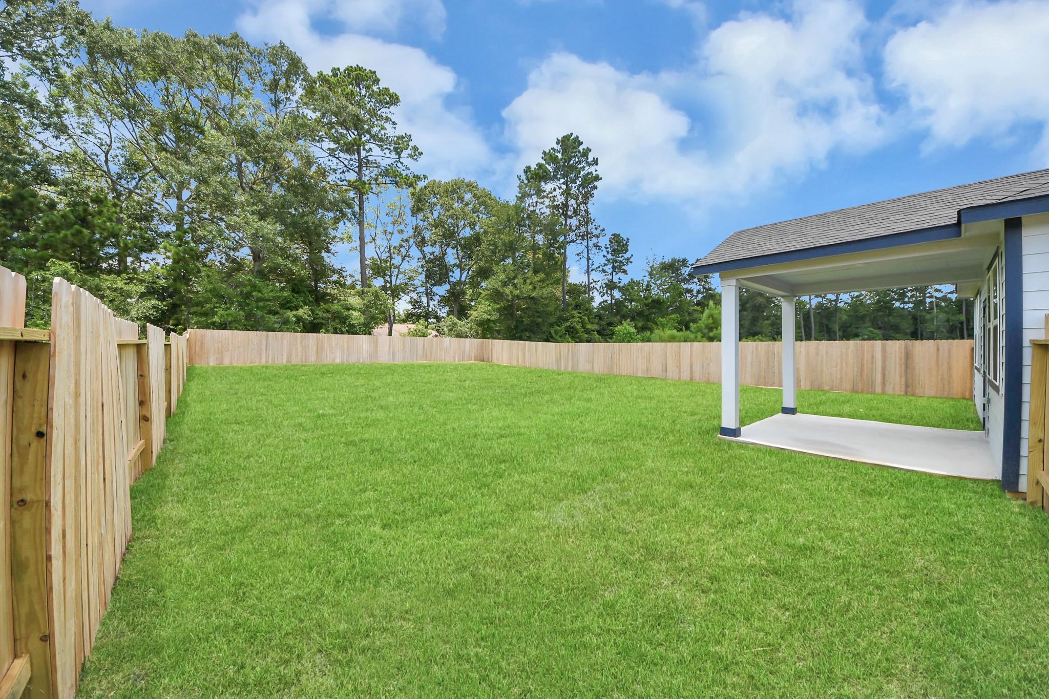 Large private fenced backyard with covered patio in Liberty Estates, Cleveland, Texas by Davidson Homes.