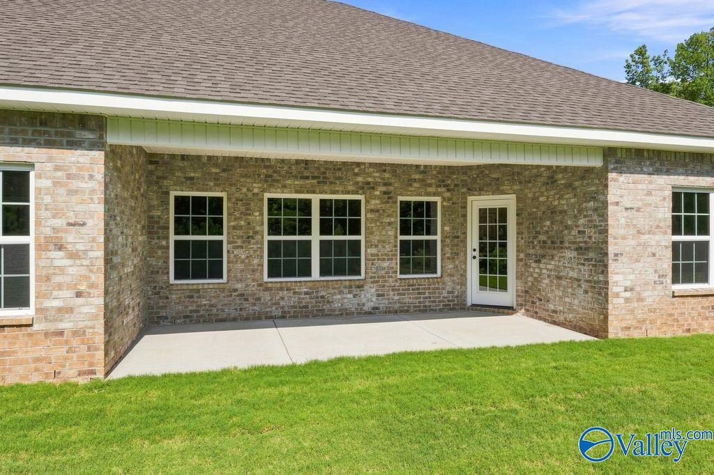 Brick exterior with covered concrete patio and glass-paneled back door at Davidson Homes The Rockford in Cain Park, Hartselle, AL