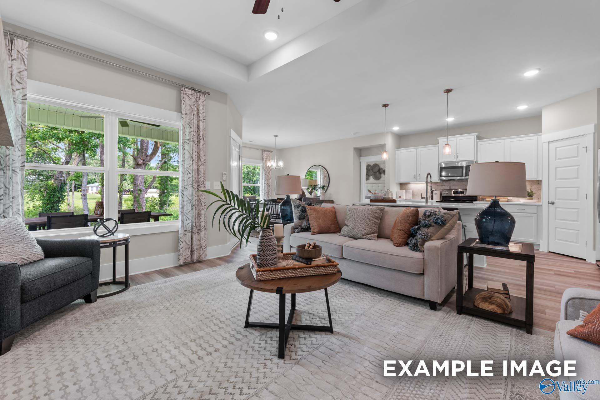 Bright open-concept living room and kitchen with white cabinetry in Davidson Homes' The Everett B, Little Creek, Arab, Alabama