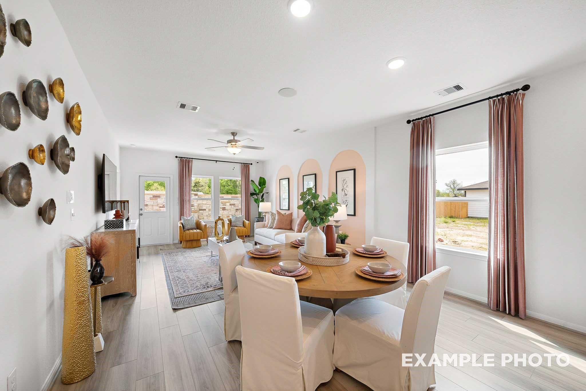 Modern open-concept living-dining space with wooden table, beige seating, and arched walls in Davidson Homes The Sabine F, Magnolia, Texas