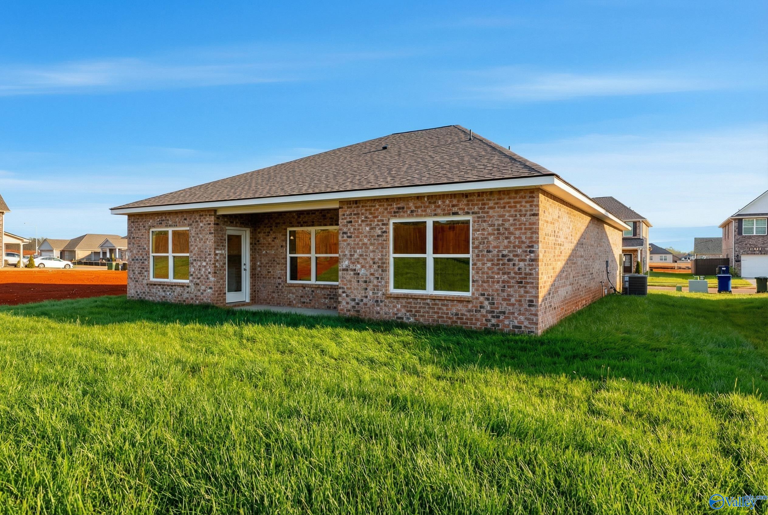 Brick single-story home with gabled shingle roof, large windows, and front door on green lawn in Walker's Hill, Meridianville, Alabama - Davidson Homes The Asheville C
