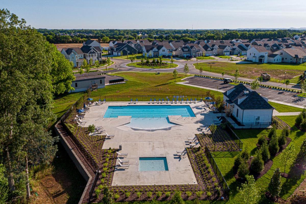 Resort-style community pool at Shelton Square in Murfreesboro TN with sundeck, lounge chairs, umbrellas, cabana, and surrounding homes