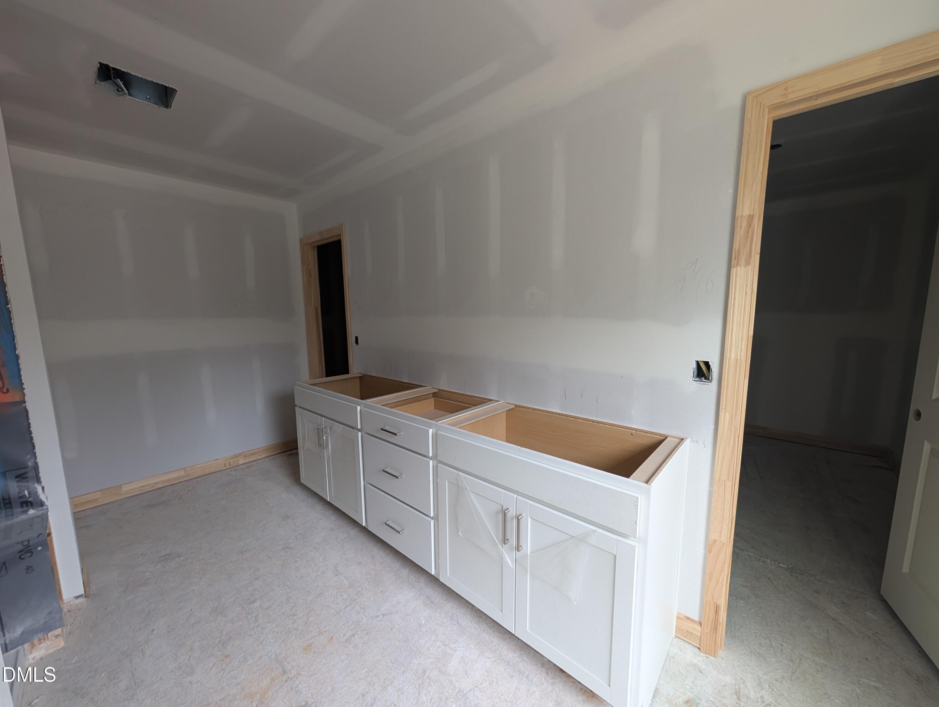 White double-sink vanity cabinets under construction in primary bathroom of Davidson Homes The Beech plan in Wendell Ridge, NC