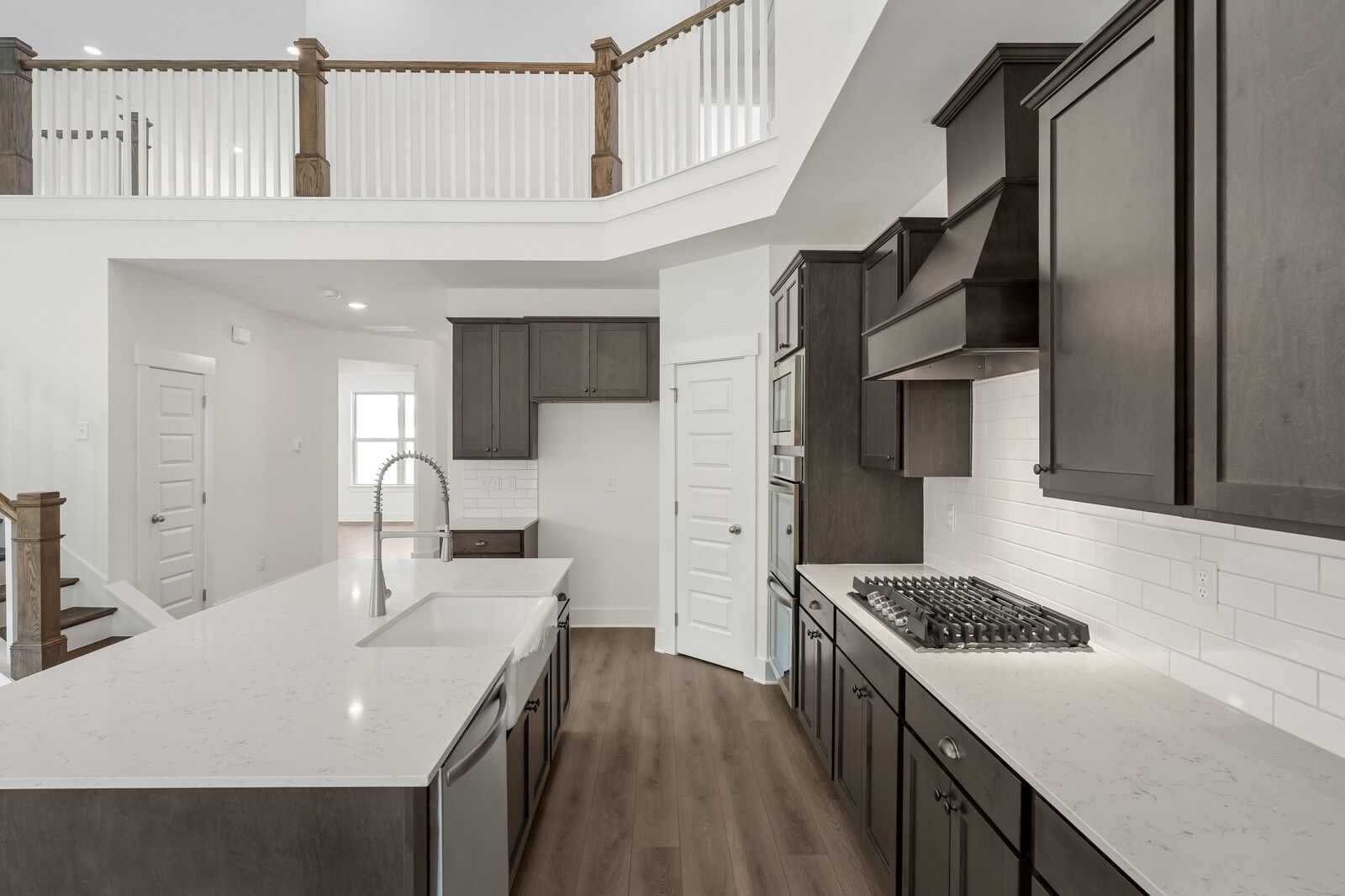 Modern kitchen with quartz island and dark cabinetry in The Ridgeport C floor plan at Woods Crossing in Gallatin, TN.