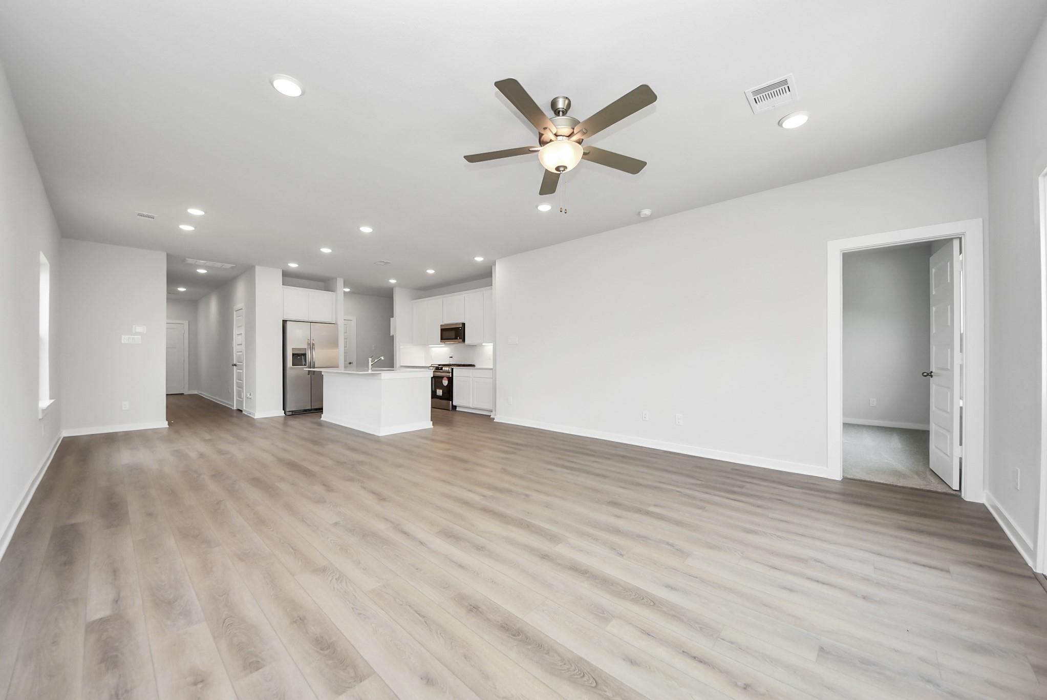 Spacious open-concept living area and kitchen in The Blanco E floor plan at The Villages at WestPointe, Dayton, Texas.