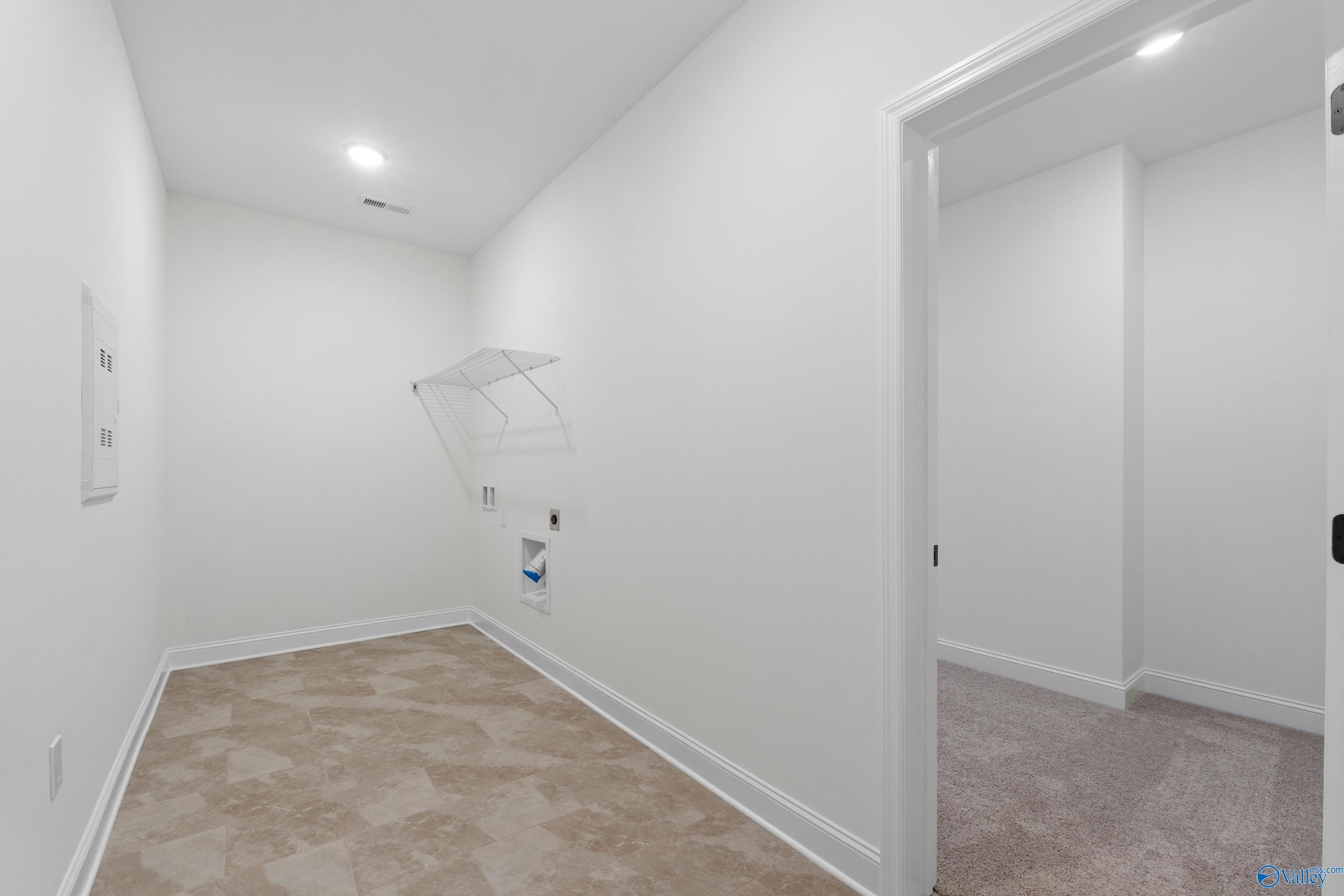 Spacious laundry room with utility sink, washer/dryer hookups and hanging rack in Davidson Homes The Rockford B, Toney, Alabama