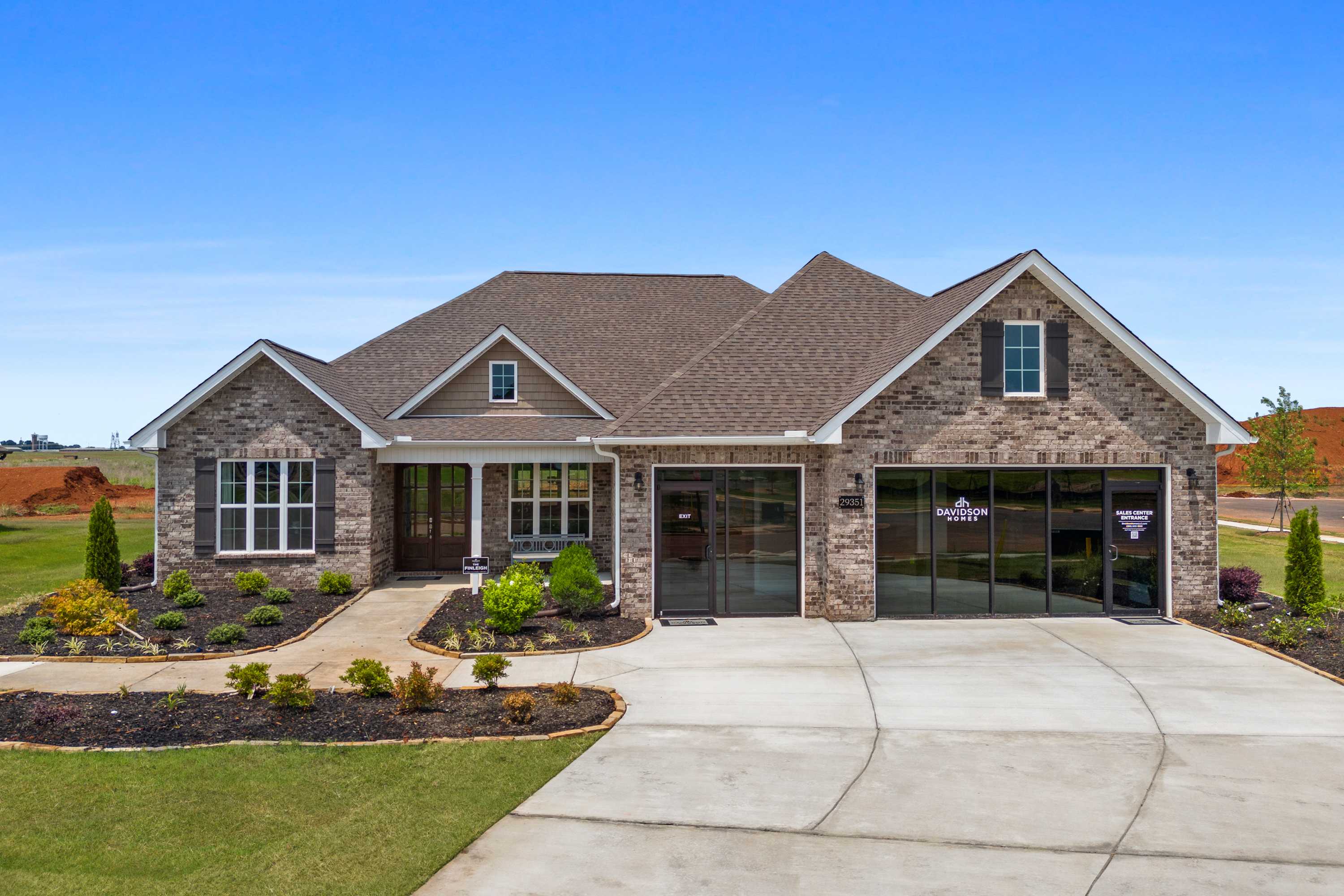 Brick stone home exterior at Creekside in Harvest Alabama with gabled roof, garage, and landscaped front yard