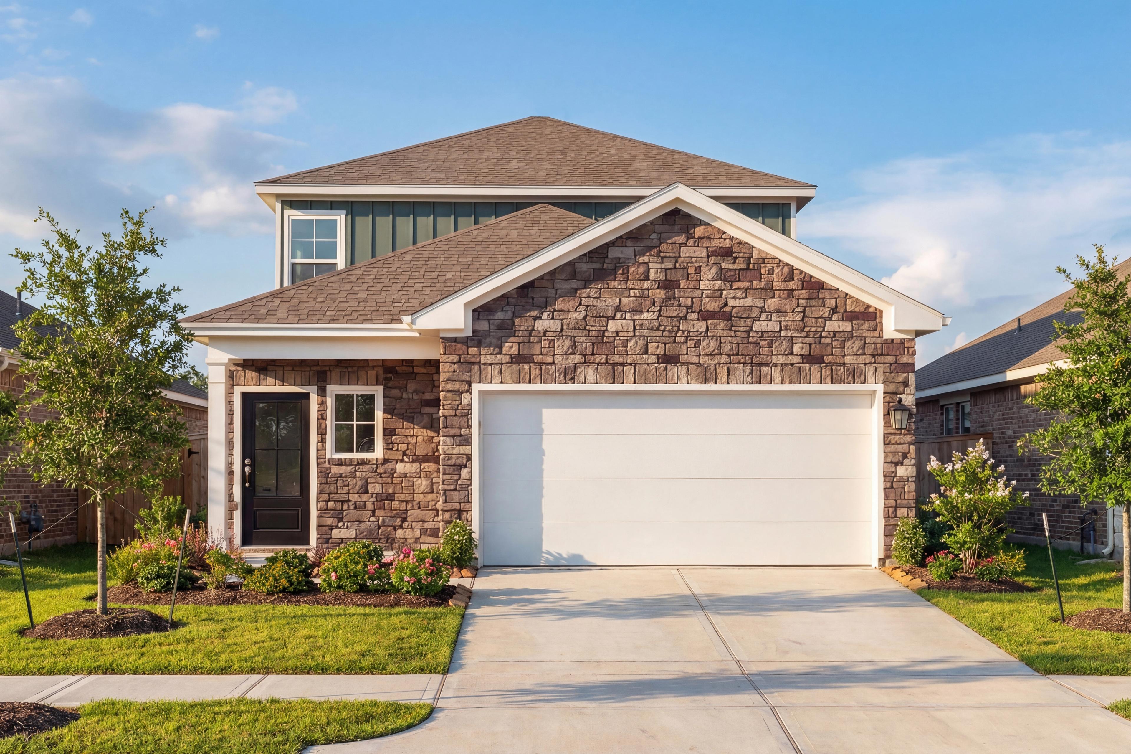 Modern two-story elevation of The Sabine E with stone accents, shingle roof, and 2-car garage amid lush landscaping