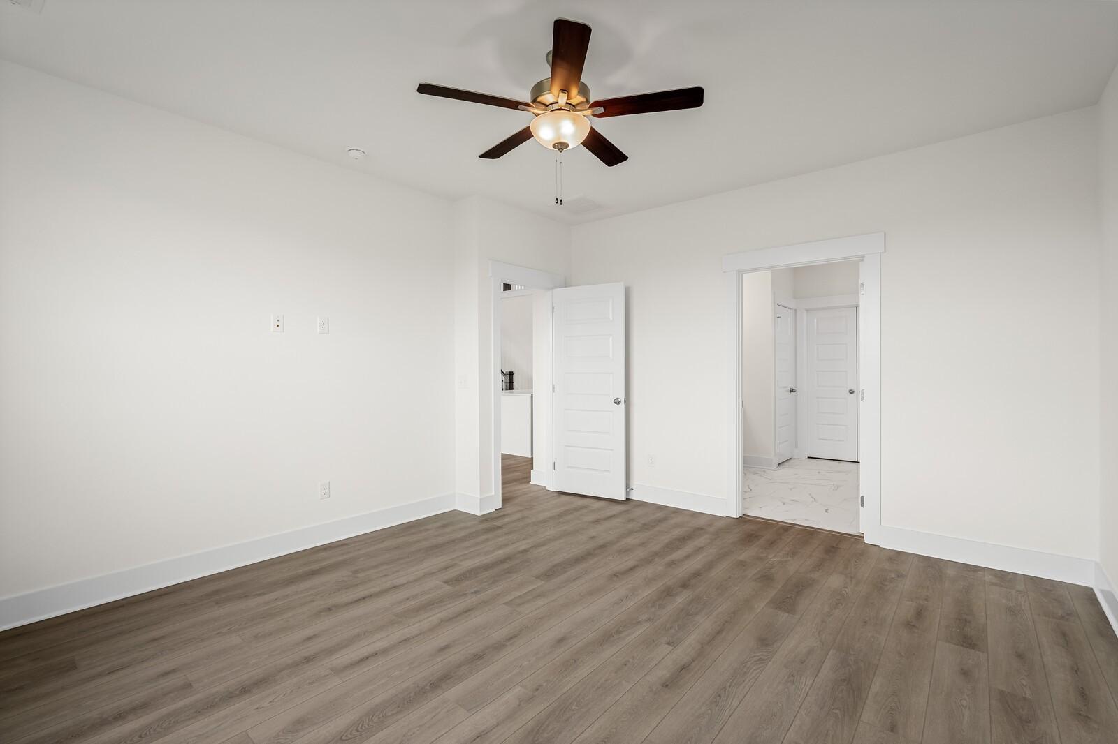 Bright, spacious bedroom with wood-style flooring and ceiling fan in The Ridgeport D floor plan, Benders Cove, Mt. Juliet.