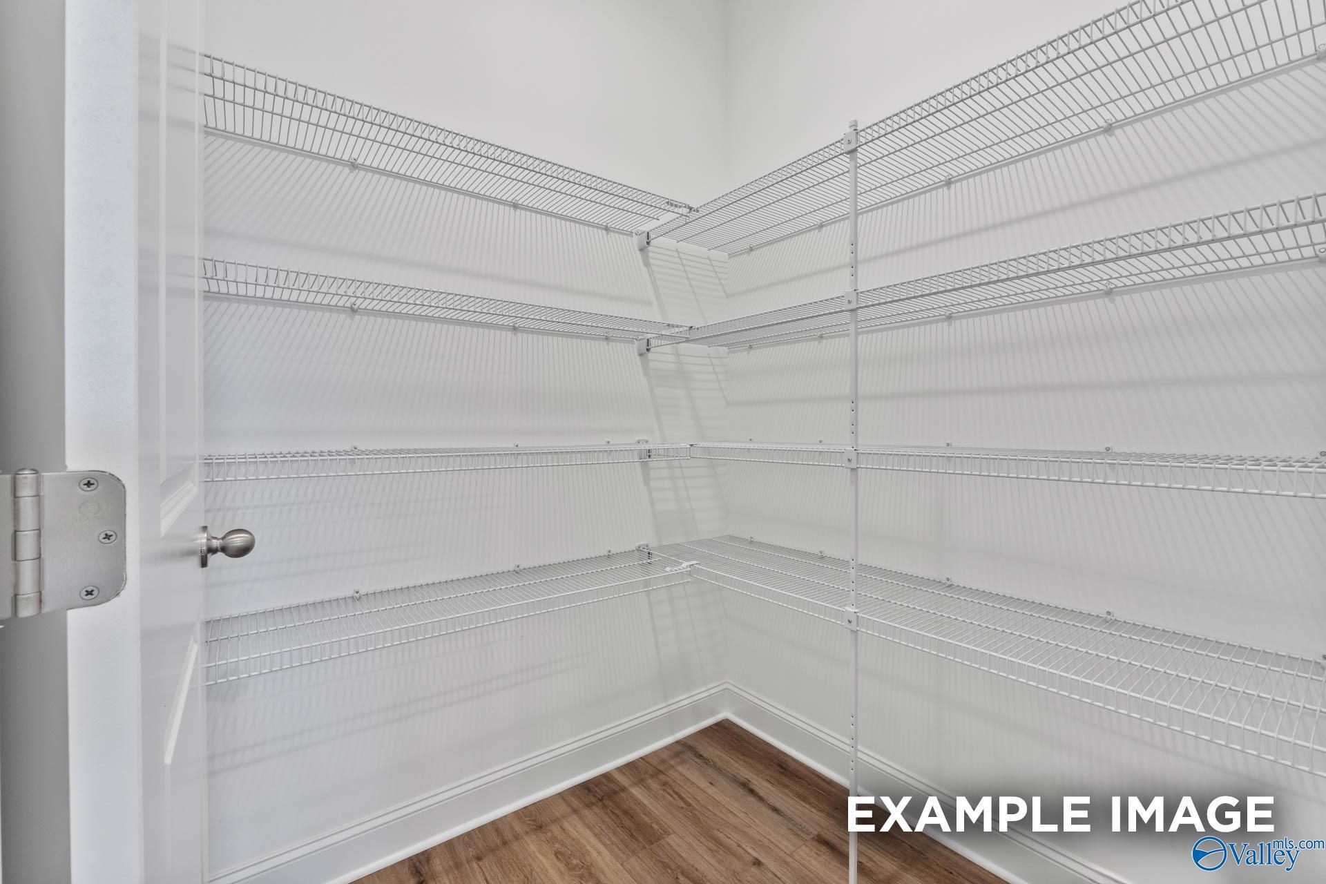 Spacious walk-in closet with white wire corner shelving in Davidson Homes The Emory, Toney, Alabama