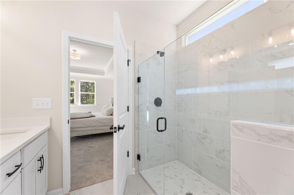 Modern master bathroom with frameless glass shower, white subway tile vanity in Davidson Homes The Daphne B, Loganville, GA