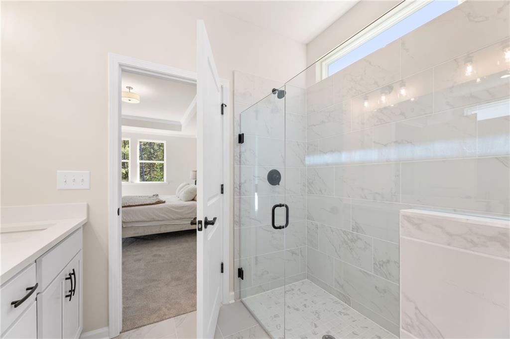 Modern master bathroom with frameless glass shower, white subway tile vanity in Davidson Homes The Daphne B, Loganville, GA