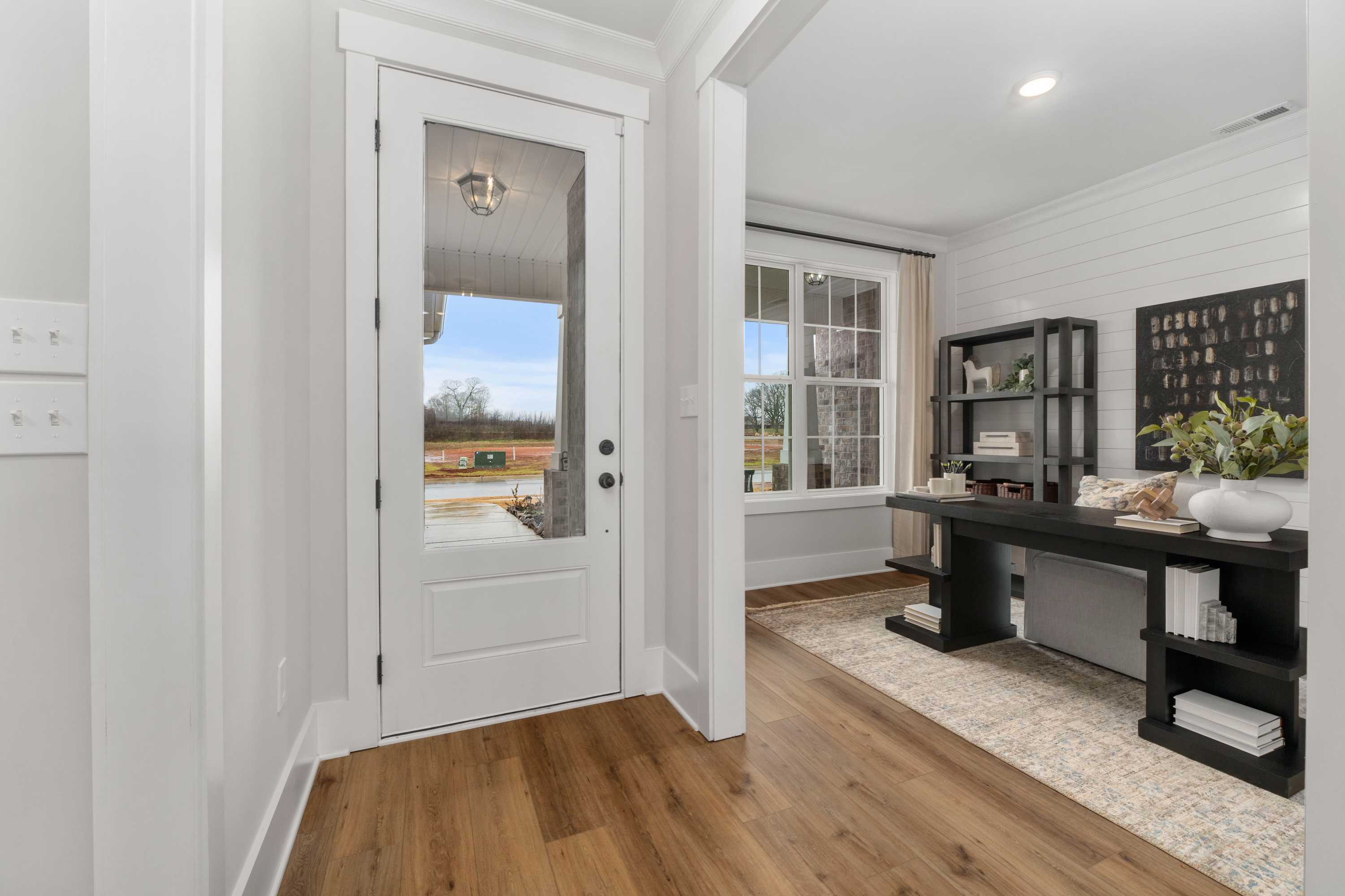 Modern home office at Kendall Farms in Toney Alabama with shiplap walls, hardwood floors, and black built-in desk