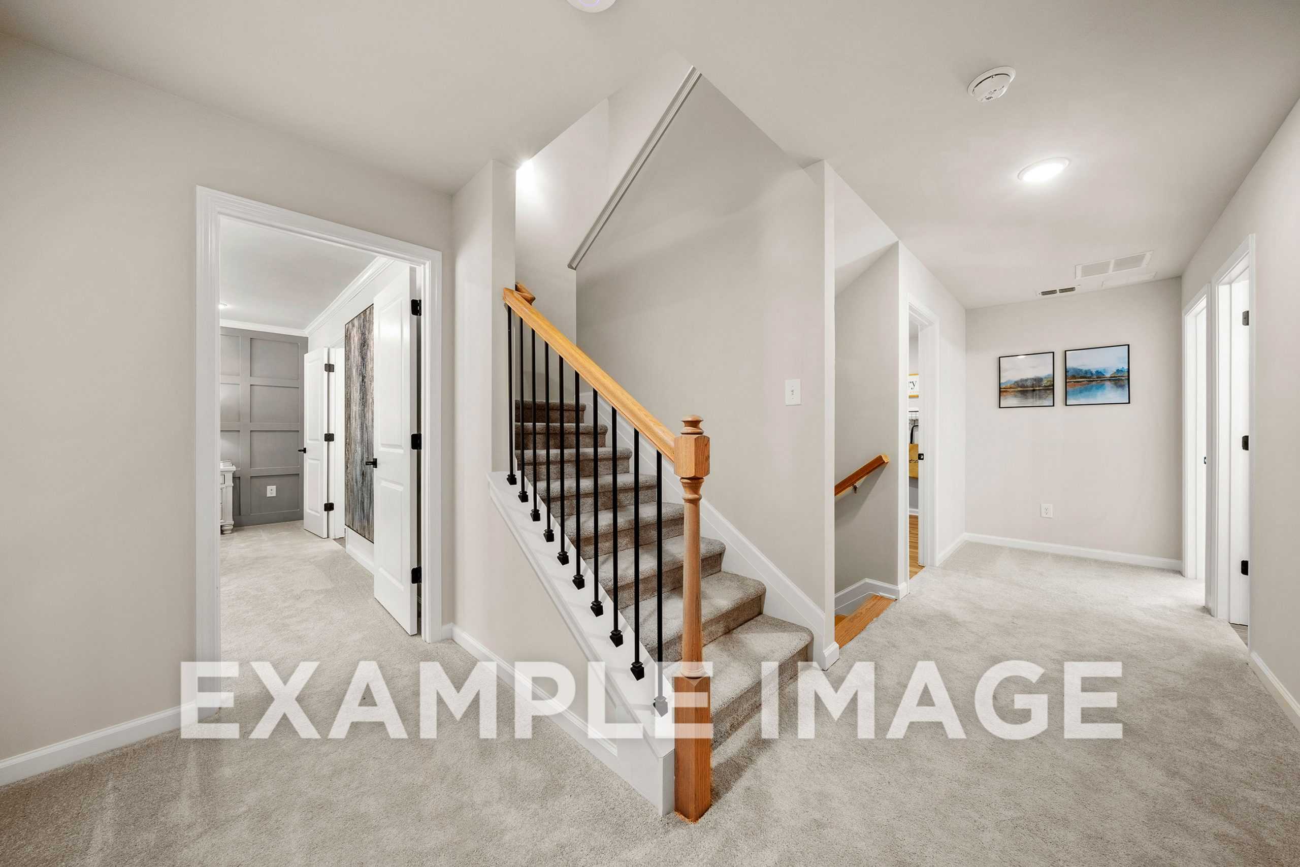Upper floor hallway in The Hickory A 2-story home design featuring oak-railed staircase, bedroom doors, and neutral walls by Davidson Homes