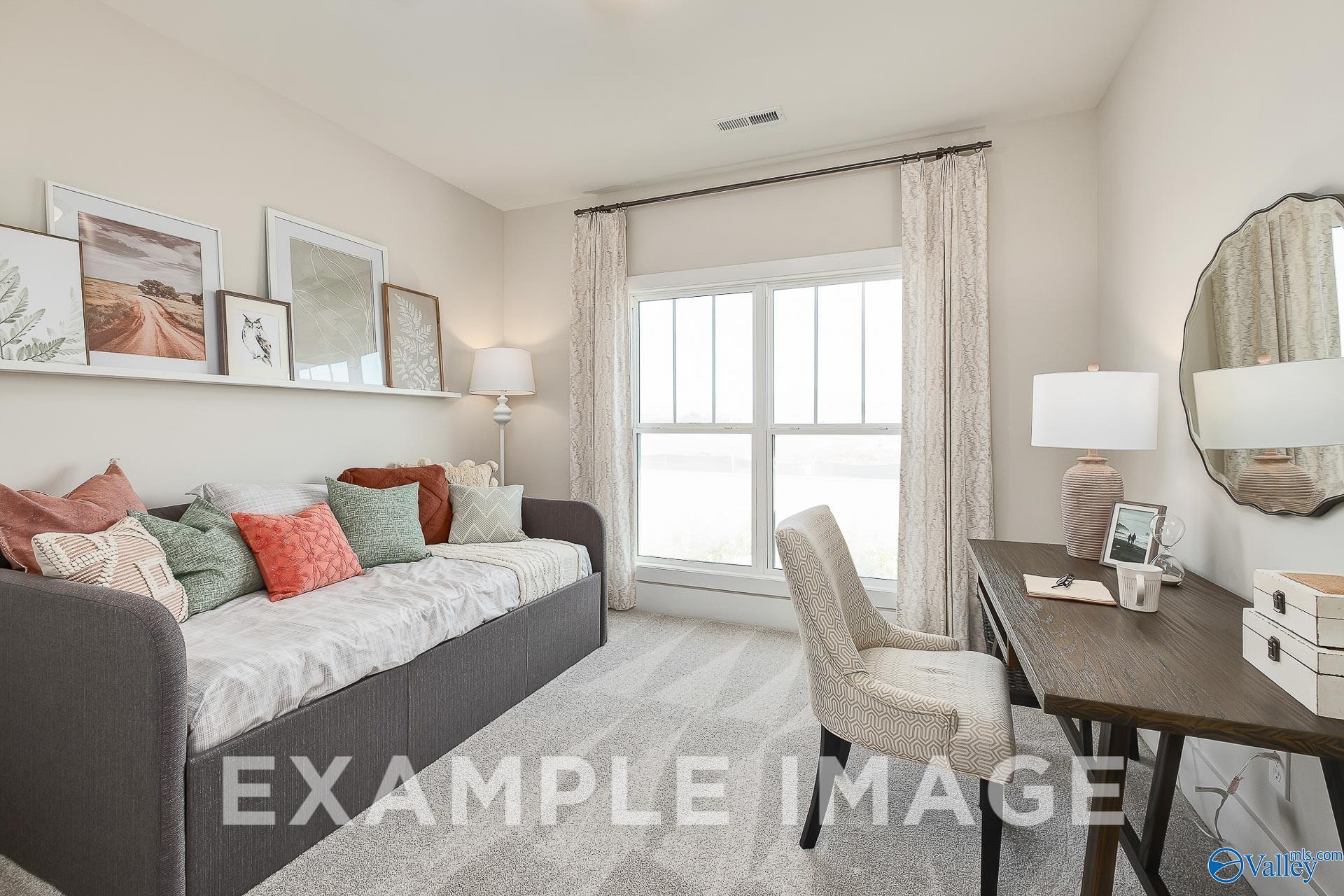 Cozy guest bedroom with daybed and home office desk in The Everett B floor plan at The Meadows in Athens, Alabama.
