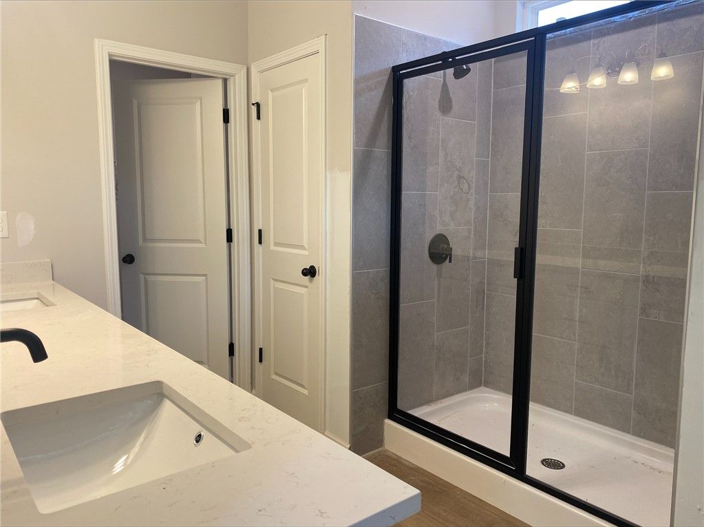 Modern primary bathroom with double vanity and walk-in glass shower in The Stella C floor plan, Links Crossing, Auburn.