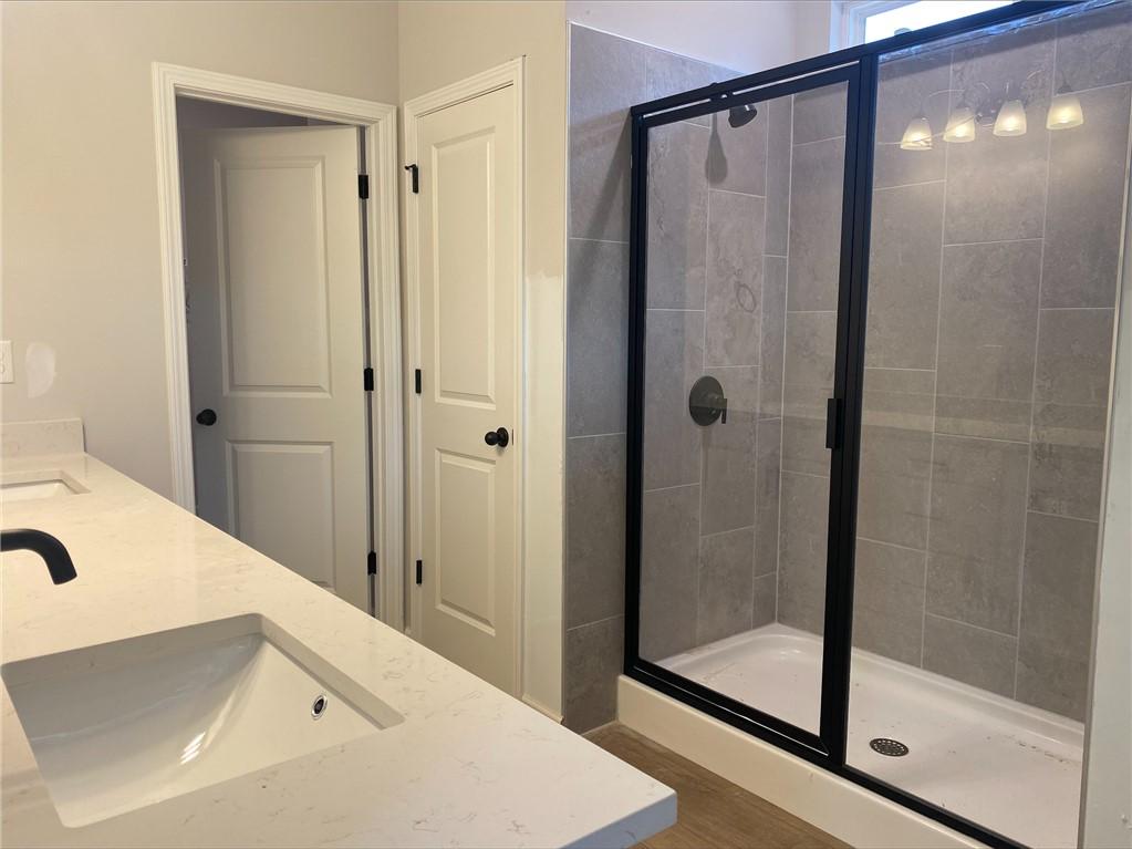 Modern primary bathroom with double vanity and walk-in glass shower in The Stella C floor plan, Links Crossing, Auburn.