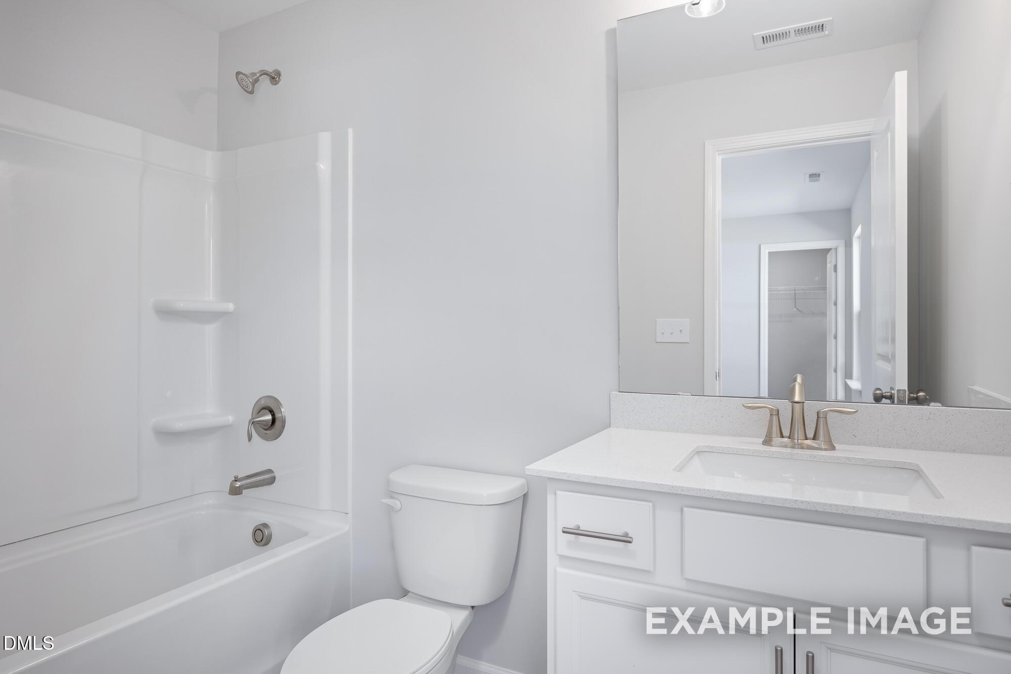 Bright white secondary bathroom with glass shower enclosure, soaking tub, and single vanity in Davidson Homes The Hickory II B, Lillington, NC