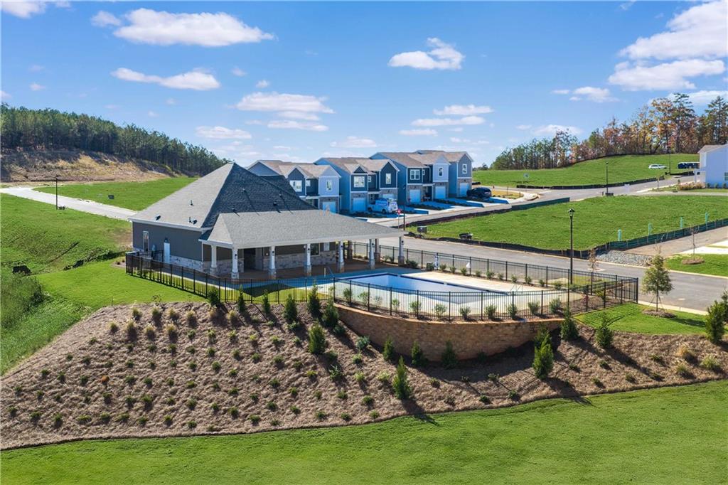 Aerial view of fenced community pool and pavilion amid new Davidson Homes townhomes in Stegall Village, Emerson, Georgia