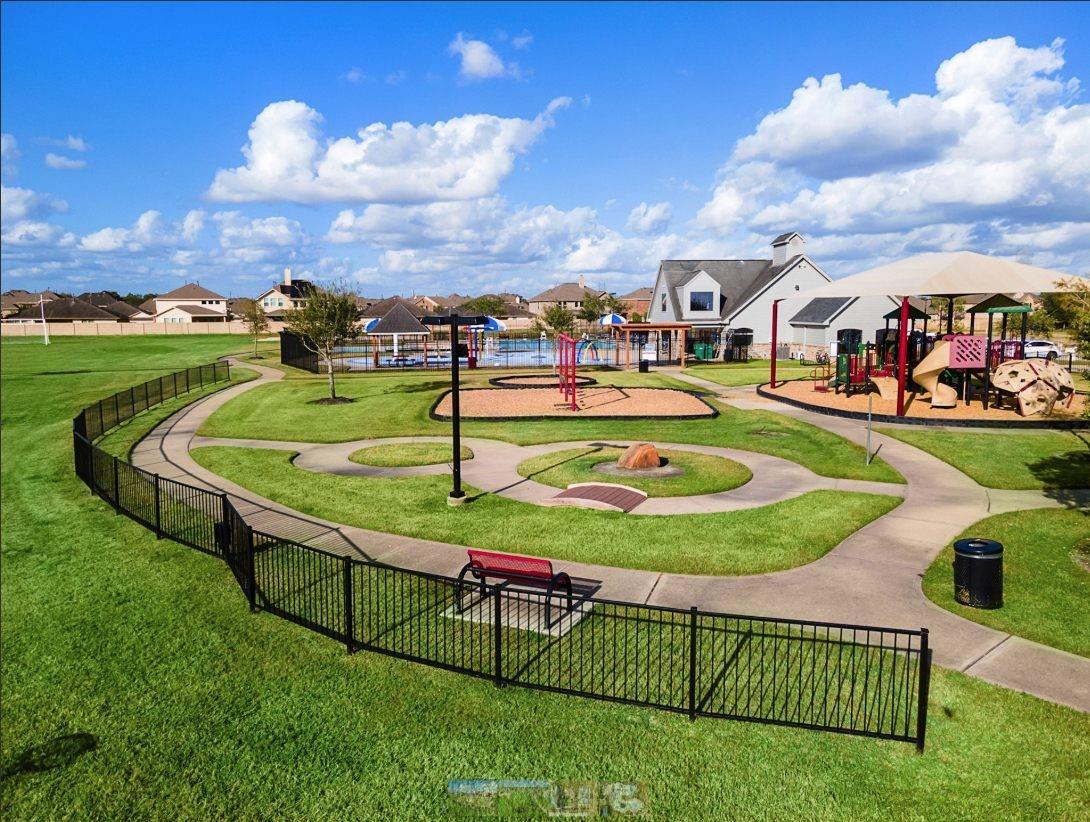 Vibrant community playground with colorful slides, climbers, benches, and winding paths in Sierra Vista, Rosharon, Texas
