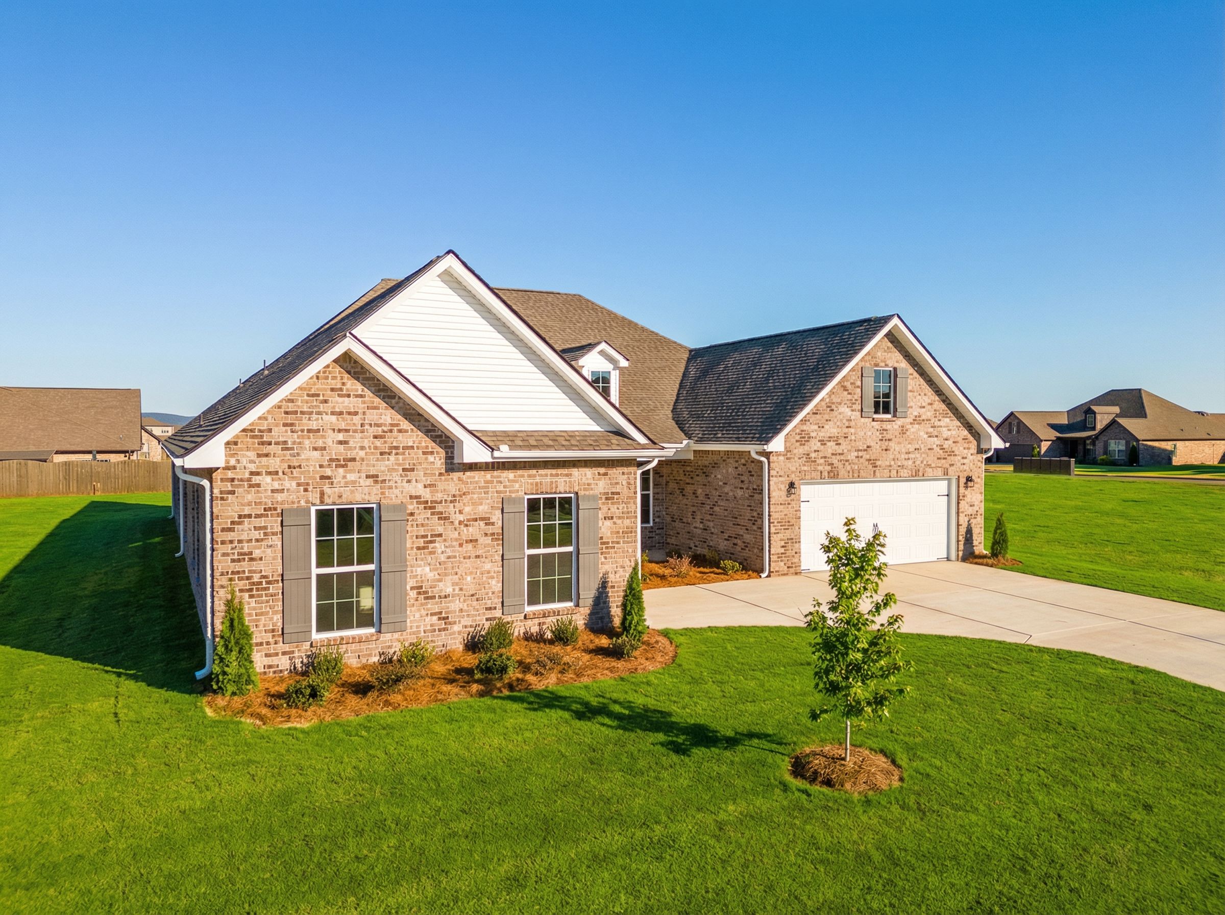Modern brick facade of The Valencia 1-story home featuring 3-car garage, gabled roof, and lush landscaped yard