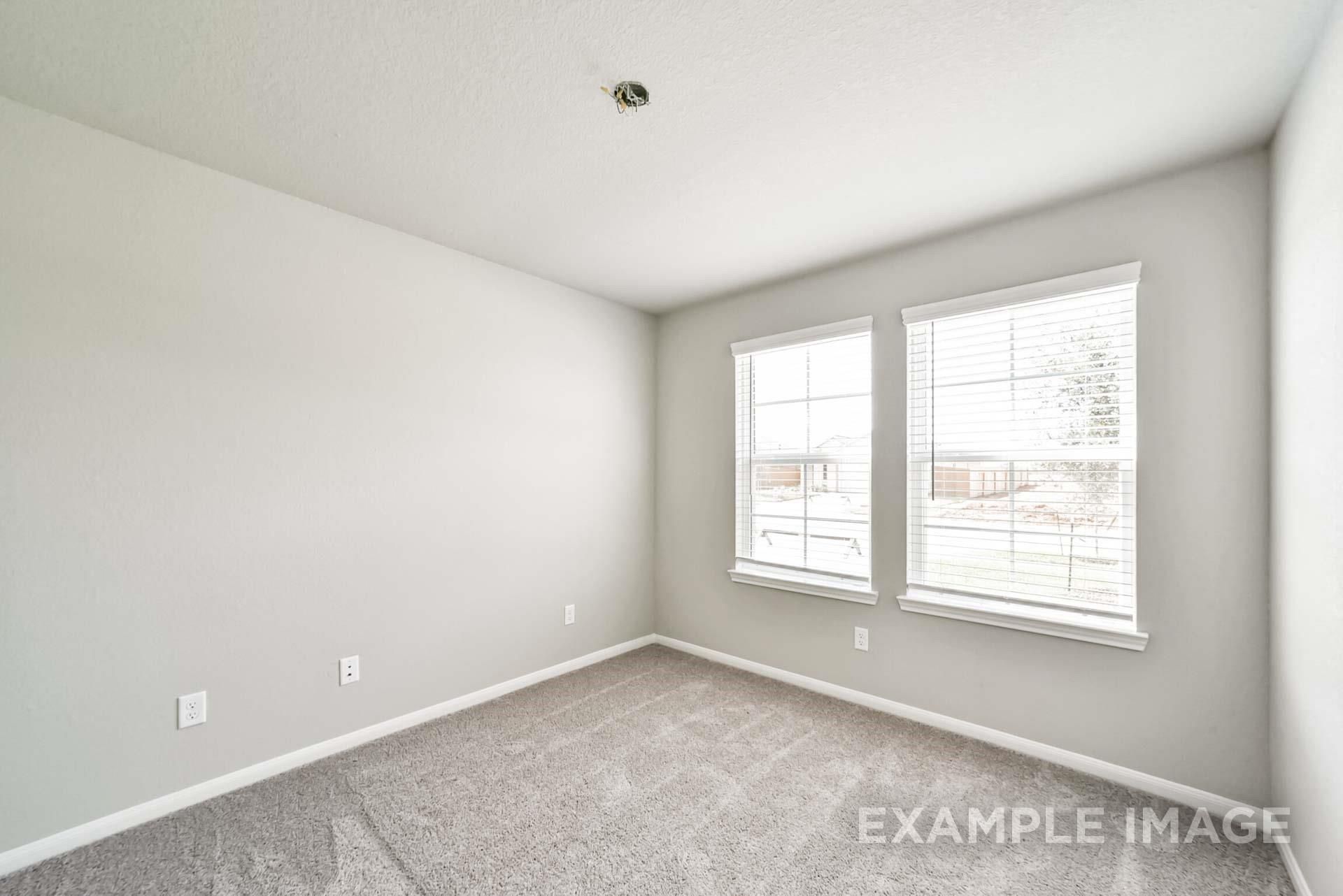 Neutral-colored secondary bedroom with plush carpeting and natural light in The Riviera A floor plan at Emberly, Beasley.