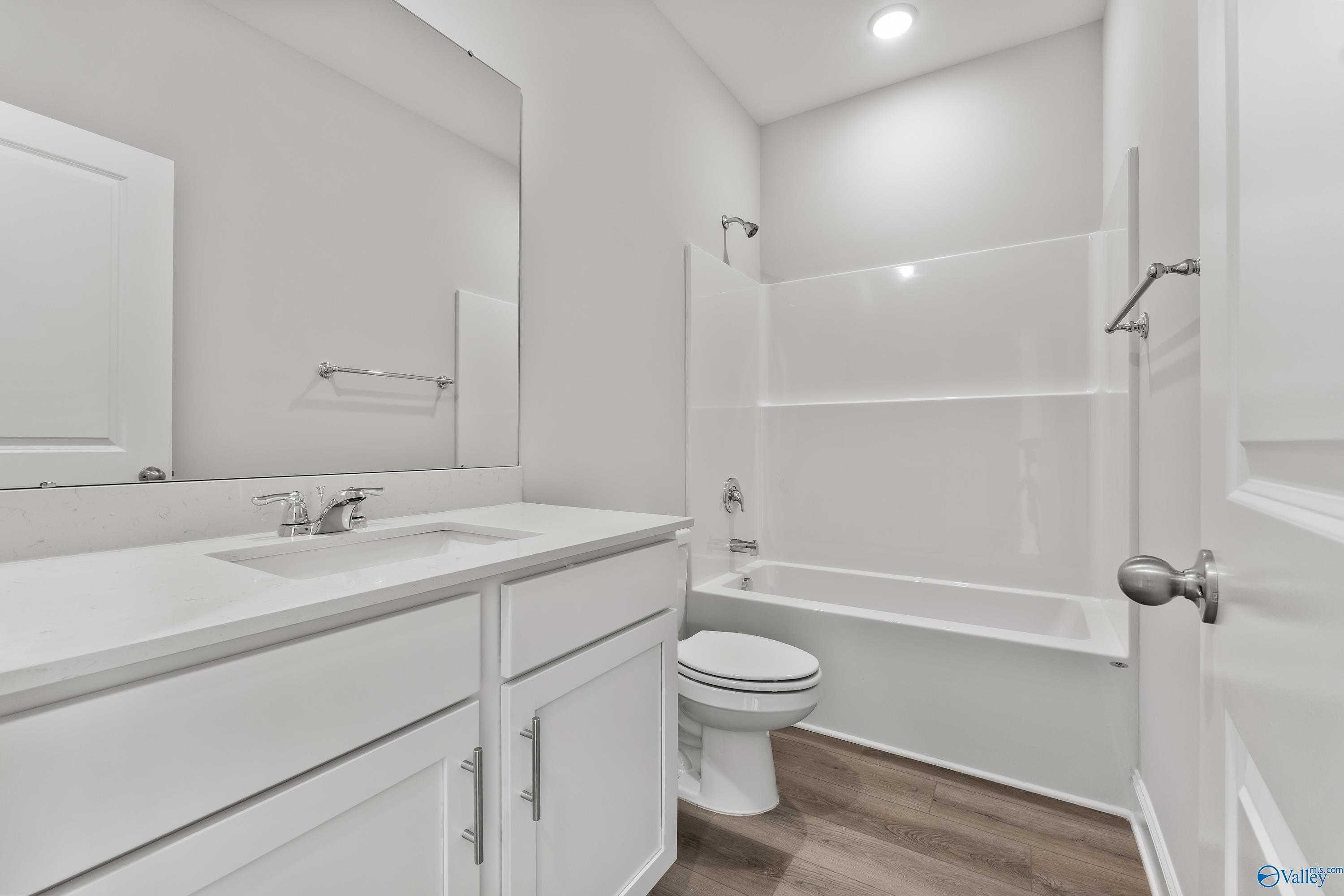 Modern guest bathroom with double vanity, white quartz counters, tub-shower combo in Davidson Homes Franklin C, Toney AL