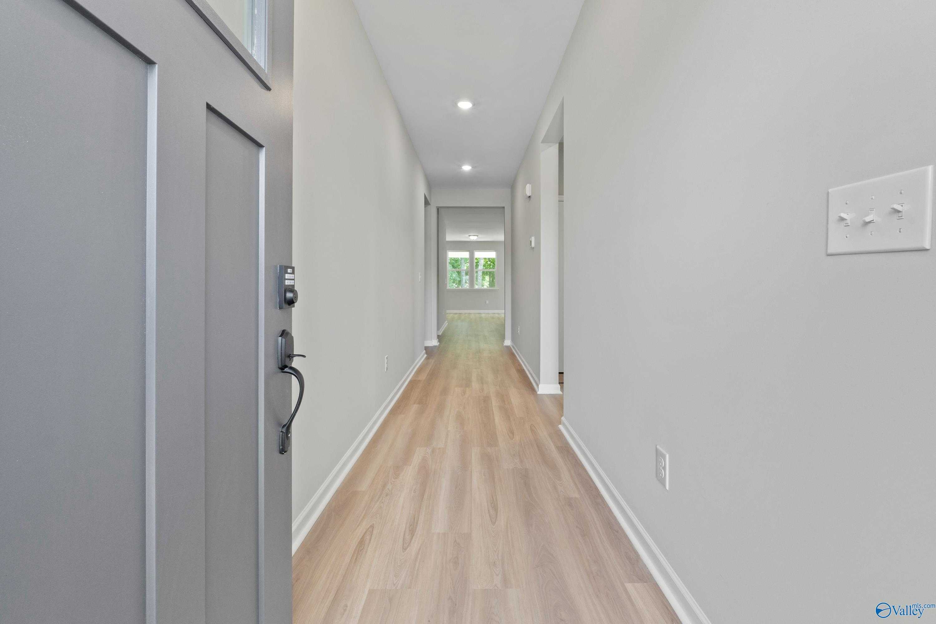 Bright entry hallway with light oak hardwood floors and pale gray walls in Davidson Homes The Phoenix, Fayetteville, TN