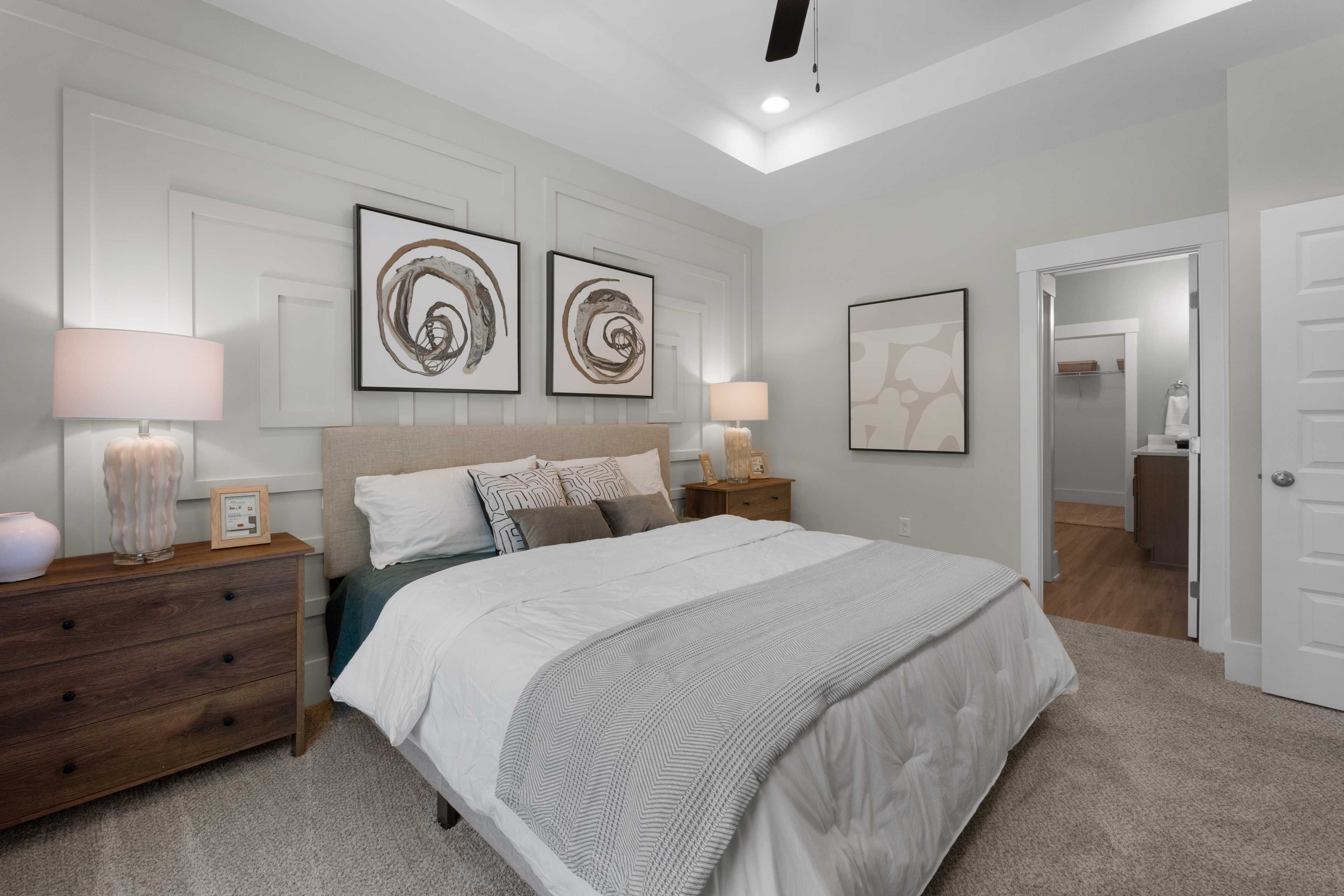 Serene master bedroom in Hollon Meadow Decatur Alabama with gray shiplap walls, king bed, abstract art, and ceiling fan