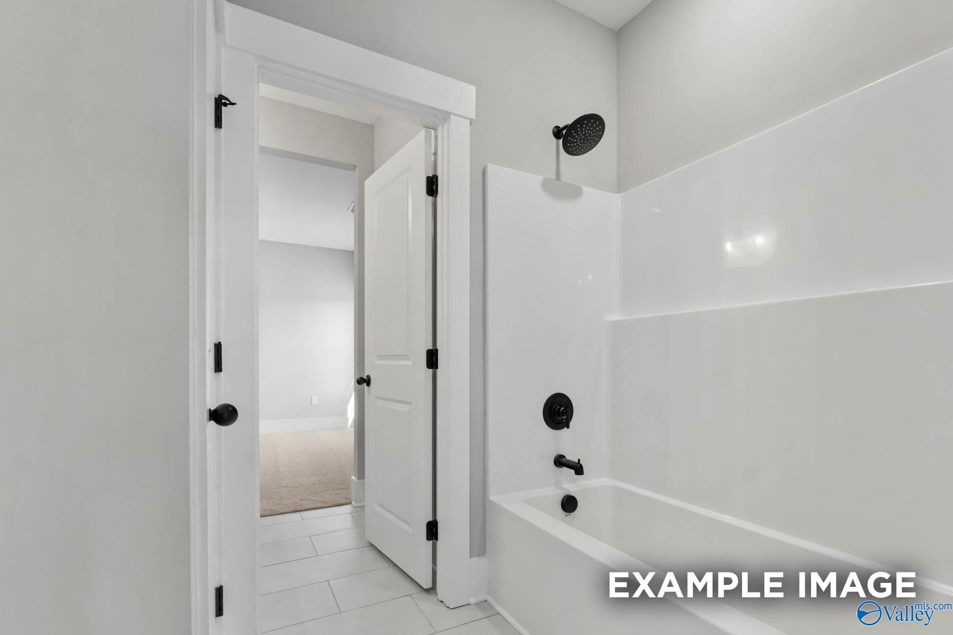 Modern bathroom with shower-tub combo and matte black fixtures in The Finleigh floor plan, Briercreek, Meridianville.