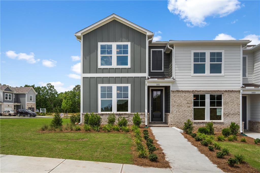 Modern two-story home with gray siding, brick accents, black door, and landscaped front yard in Stegall Village, Emerson, Georgia