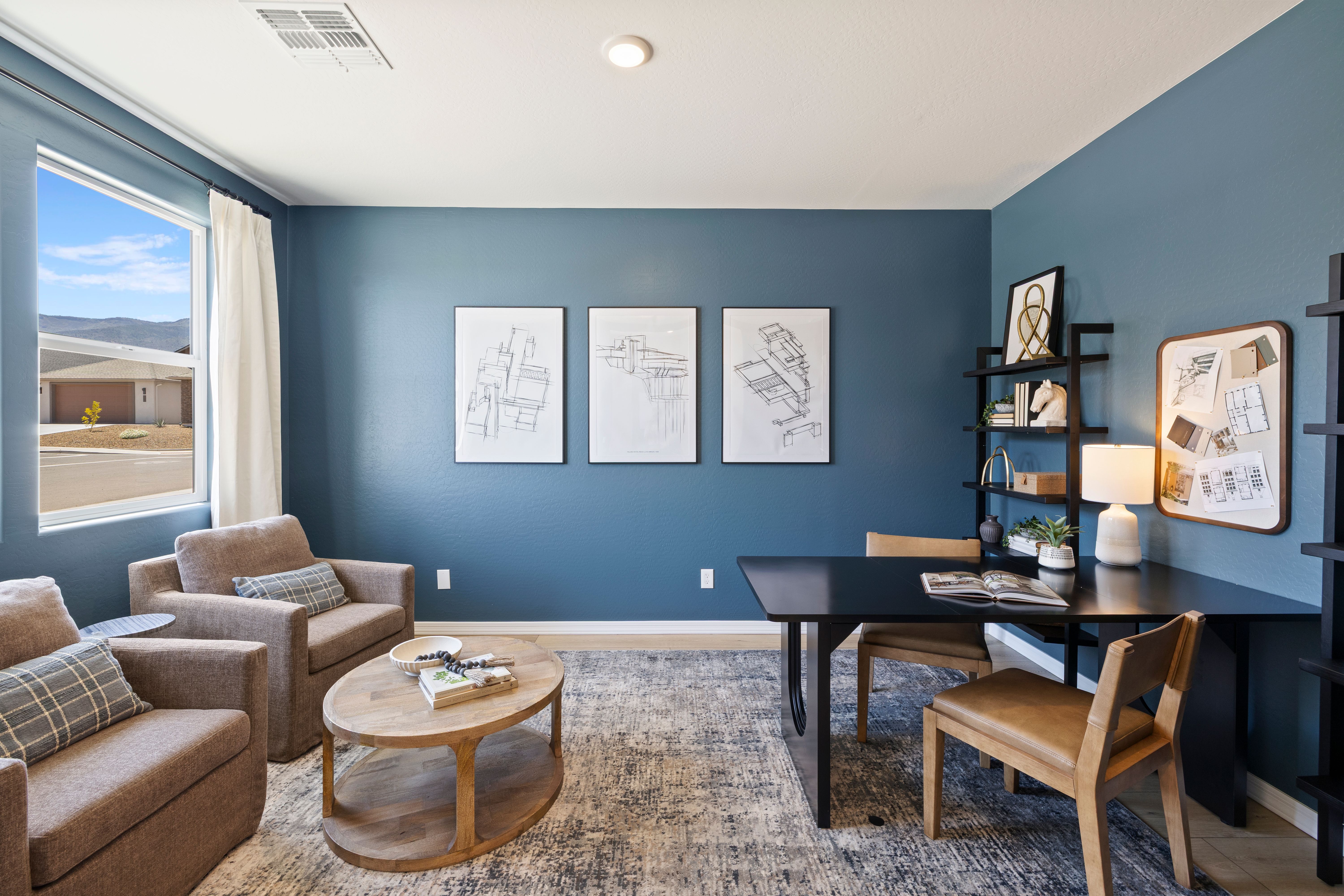 Modern home office with blue walls, desert mountain view, wooden desk, armchairs at Vineyards at Cottonwood, Cottonwood AZ