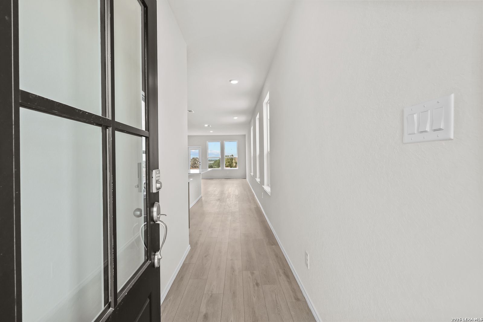 Bright entryway with modern wood-style flooring in The Gillian B floor plan at Meadows at Oak Creek, San Antonio, Texas.