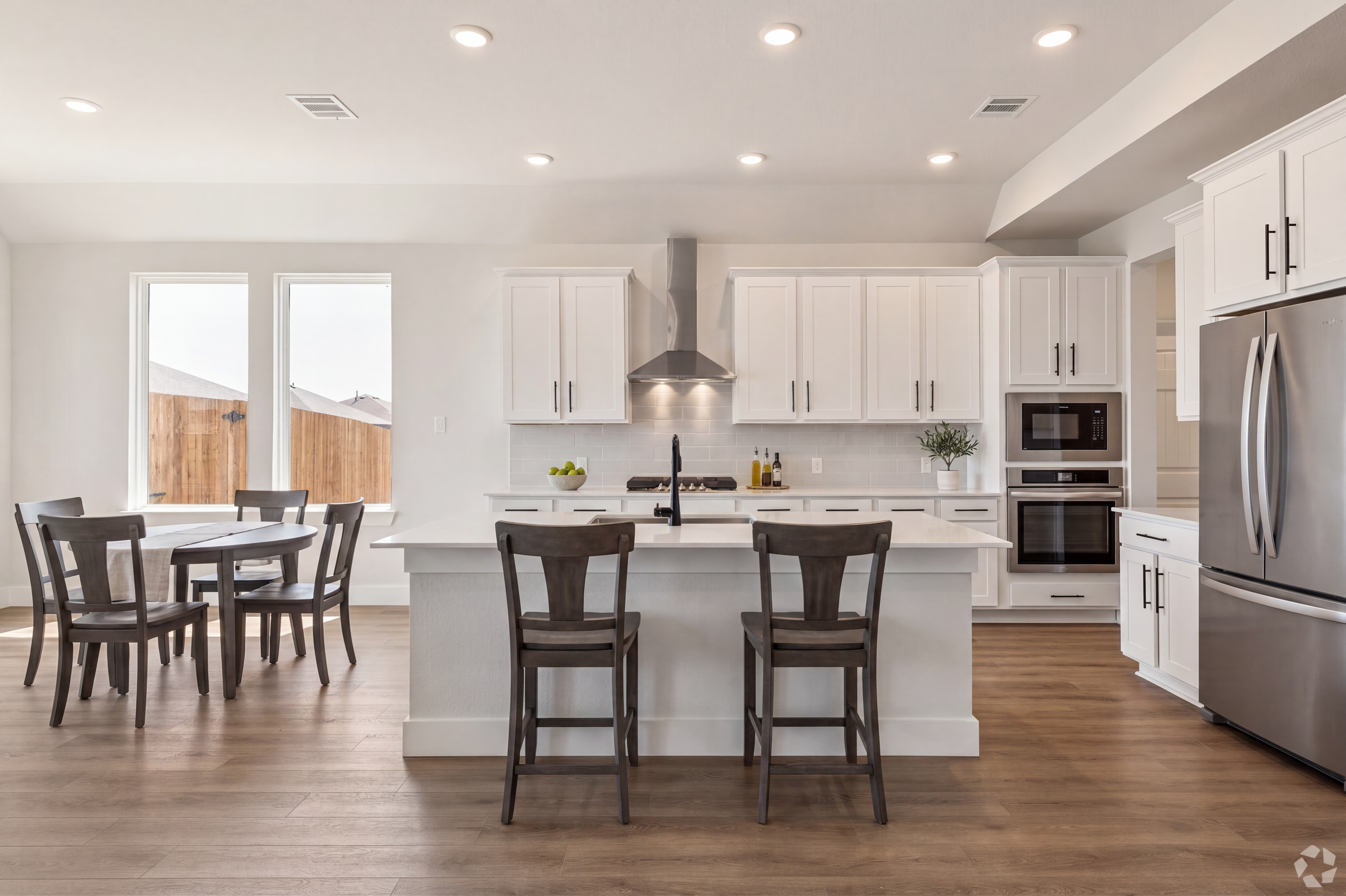 open concept kitchen with white cabinets, stainless appliances and large island