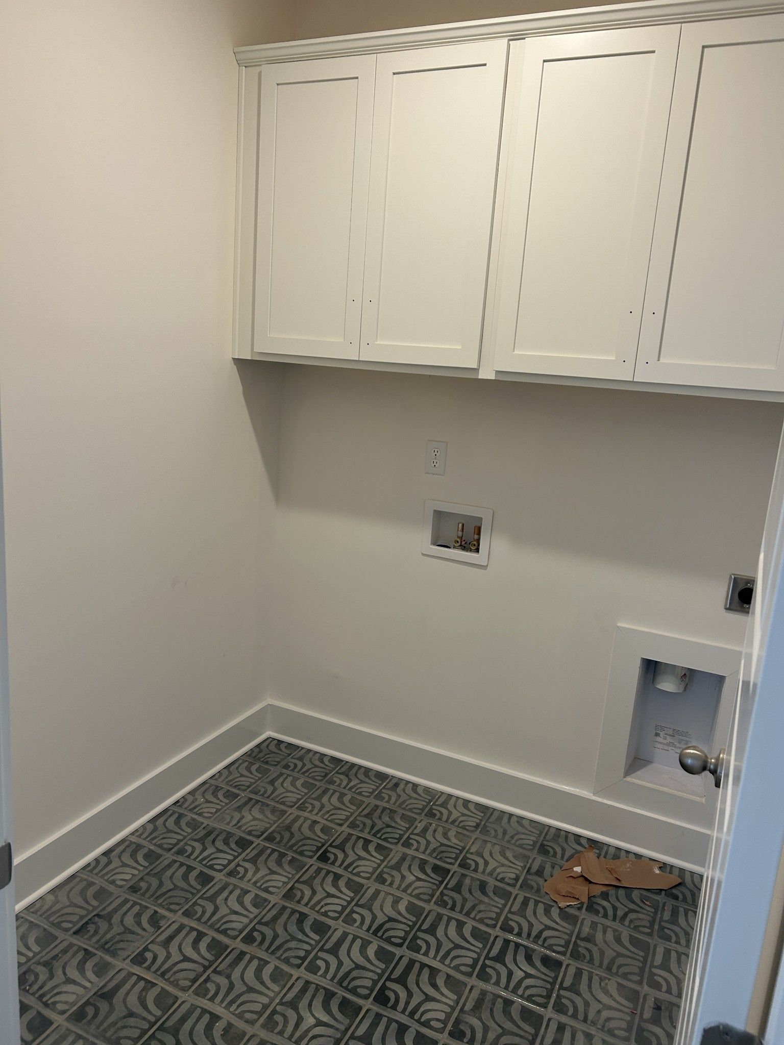 Modern laundry room with white shaker cabinets, utility sink, and blue mosaic tile floor in Davidson Homes Ridgeport D, Mt. Juliet