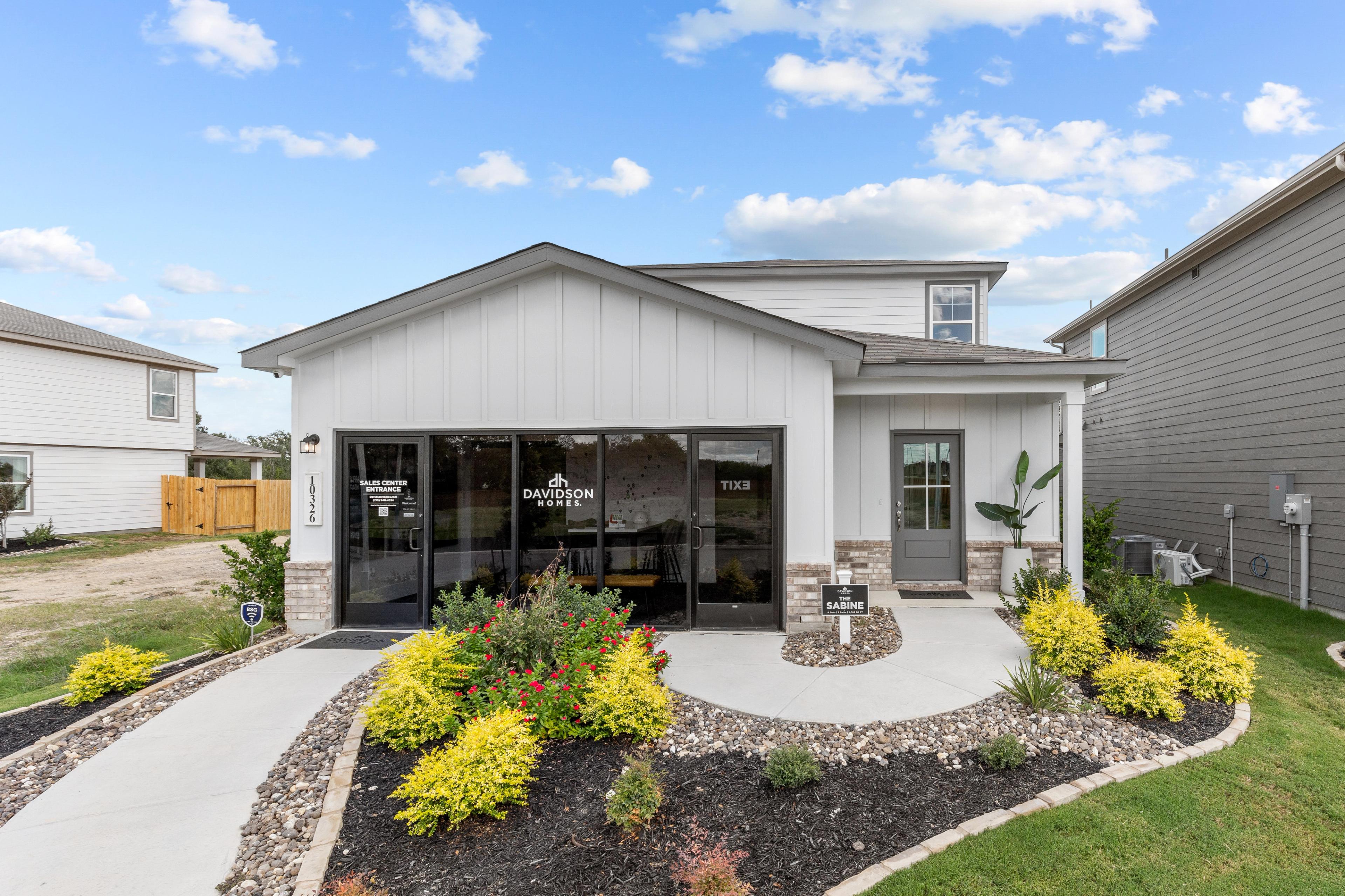 Modern home exterior at Applewhite Meadows in San Antonio TX by Davidson Homes featuring attached garage, covered entry, and vibrant landscaping