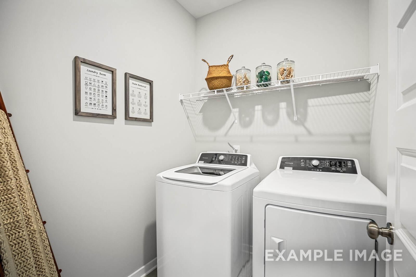 Modern laundry room in The Franklin B featuring white washer dryer, wire shelving, storage baskets, and neutral decor