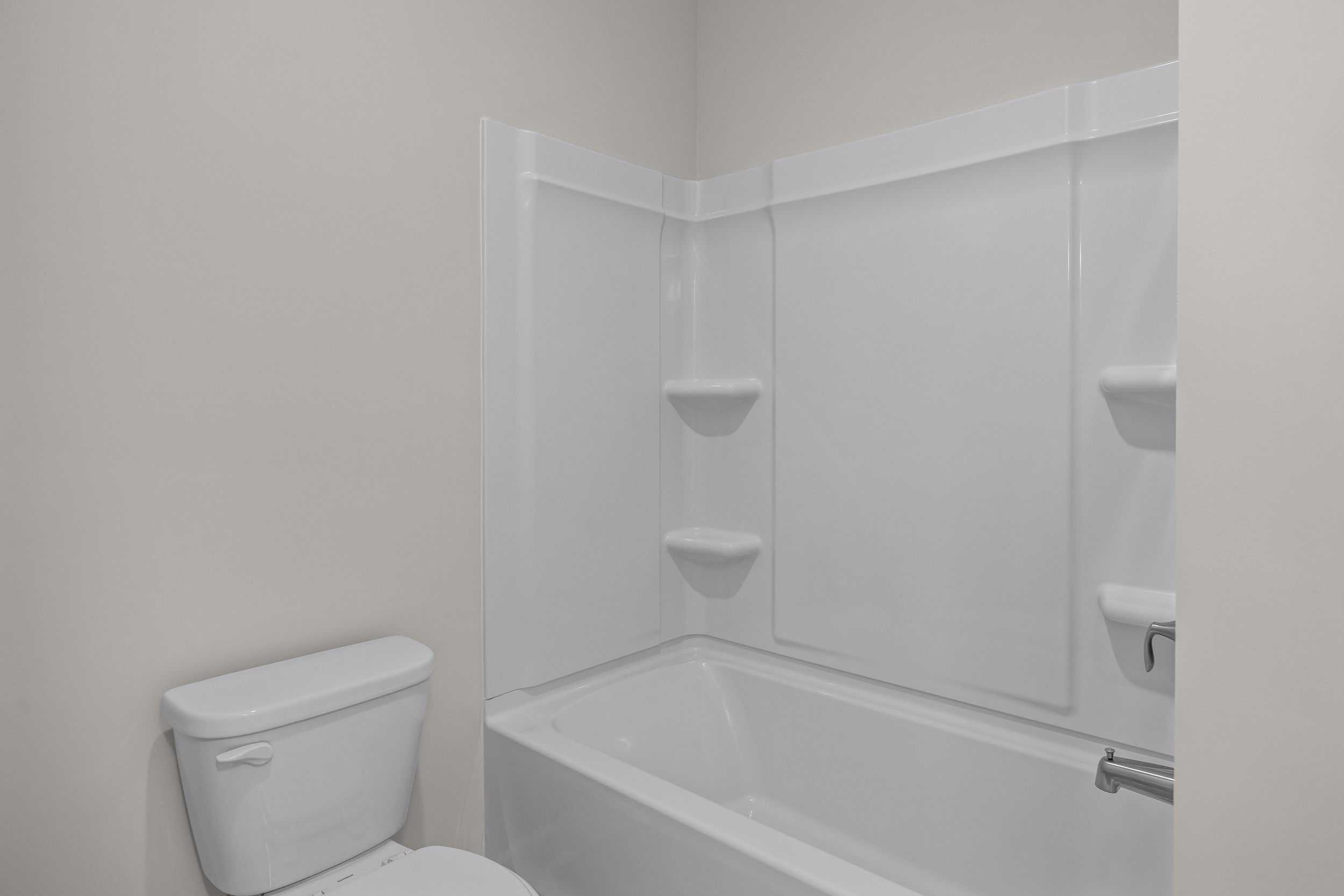Contemporary secondary bathroom in The Aspen Davidson Homes design: white tub-shower combo with shelves and toilet