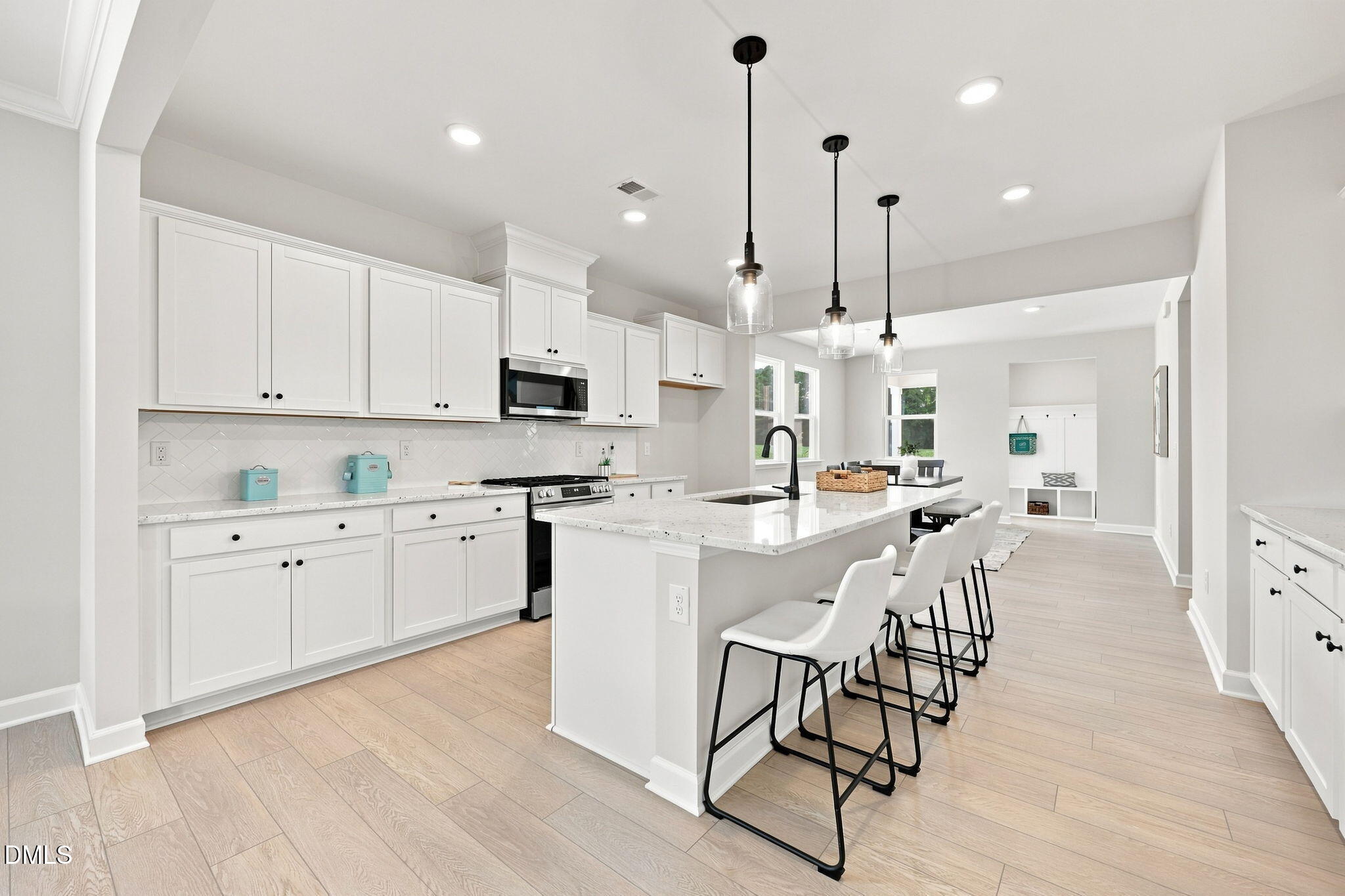 Modern white kitchen with island seating in The Harris C floor plan at Forestville Yard, Knightdale, North Carolina.