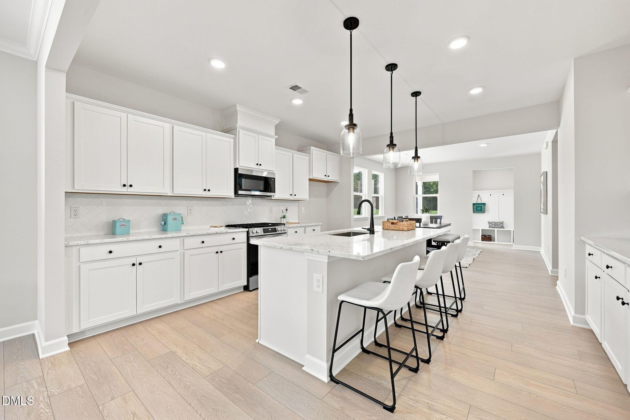 Modern white kitchen with island seating in The Harris C floor plan at Forestville Yard, Knightdale, North Carolina.