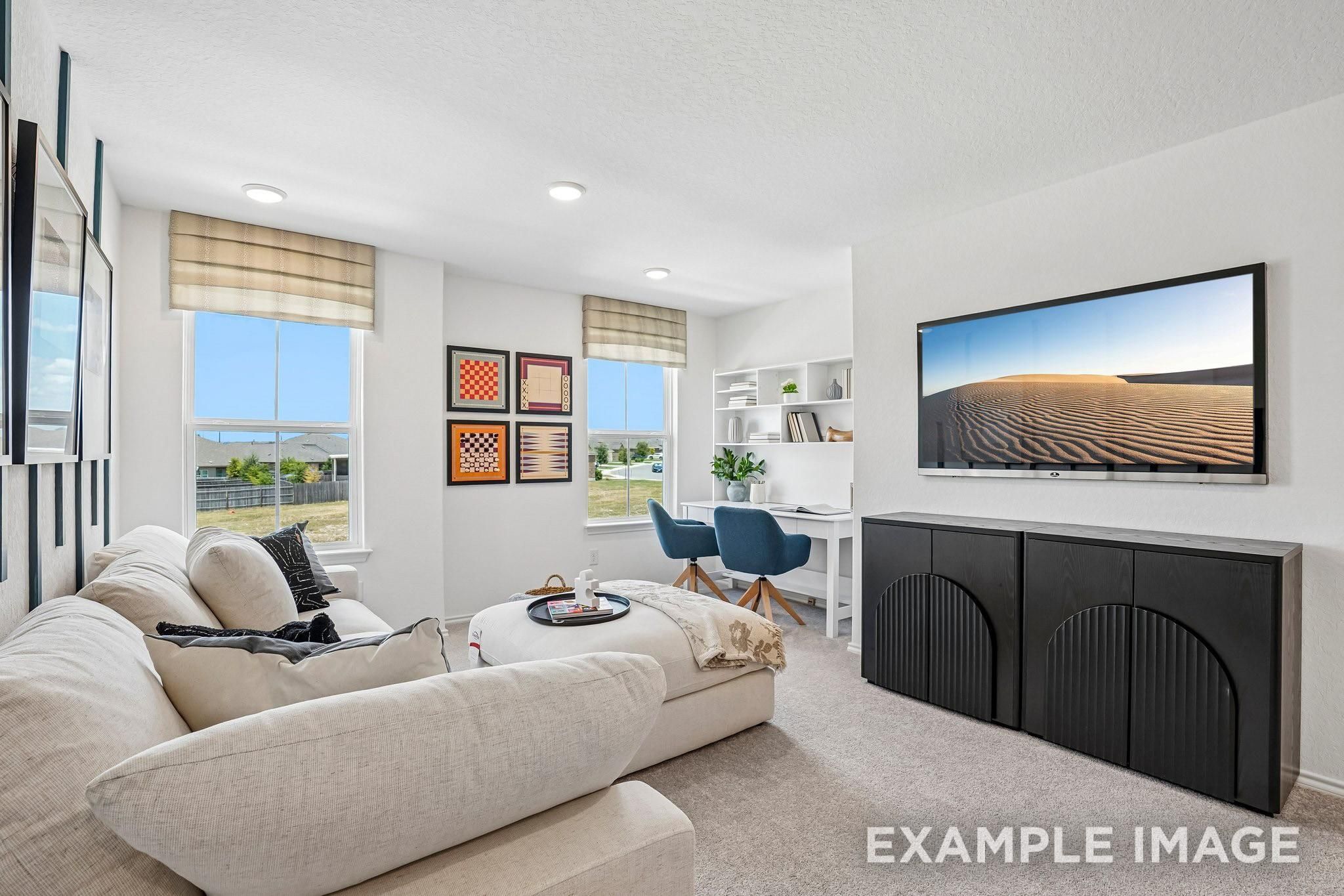 Bright game room loft with sectional sofa, wall-mounted TV, and built-in desk in Davidson Homes The Ashport J, Crosby, Texas