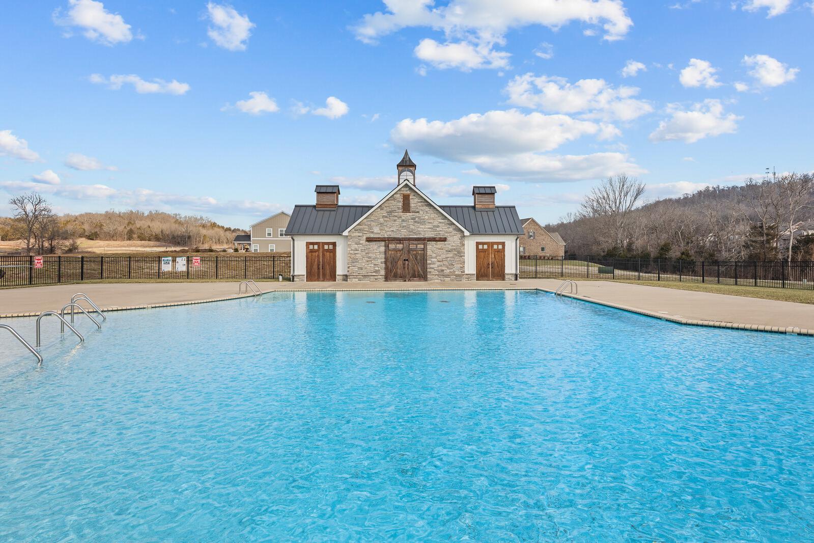 Sparkling blue community swimming pool at Carellton in Gallatin, Tennessee with stone clubhouse pavilion and pool deck
