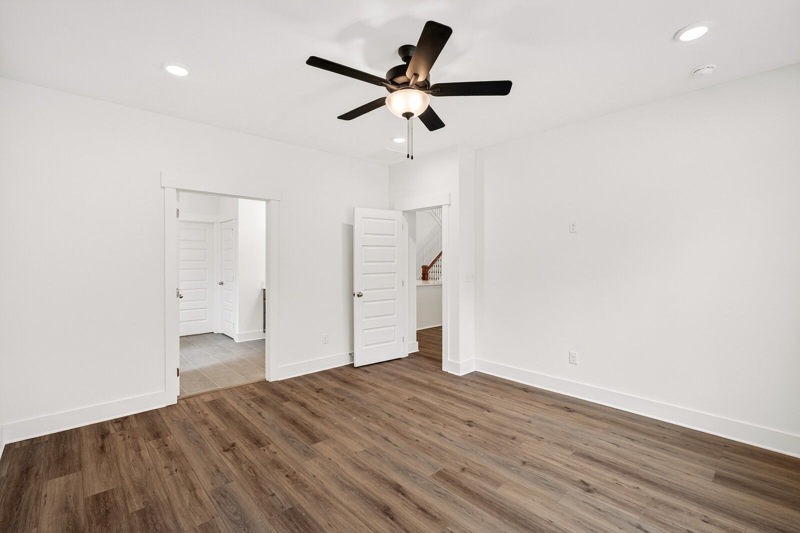 Spacious bedroom with hardwood floors, ceiling fan, recessed lights, and en-suite bathroom in Davidson Homes Ridgeport C, Gallatin, TN