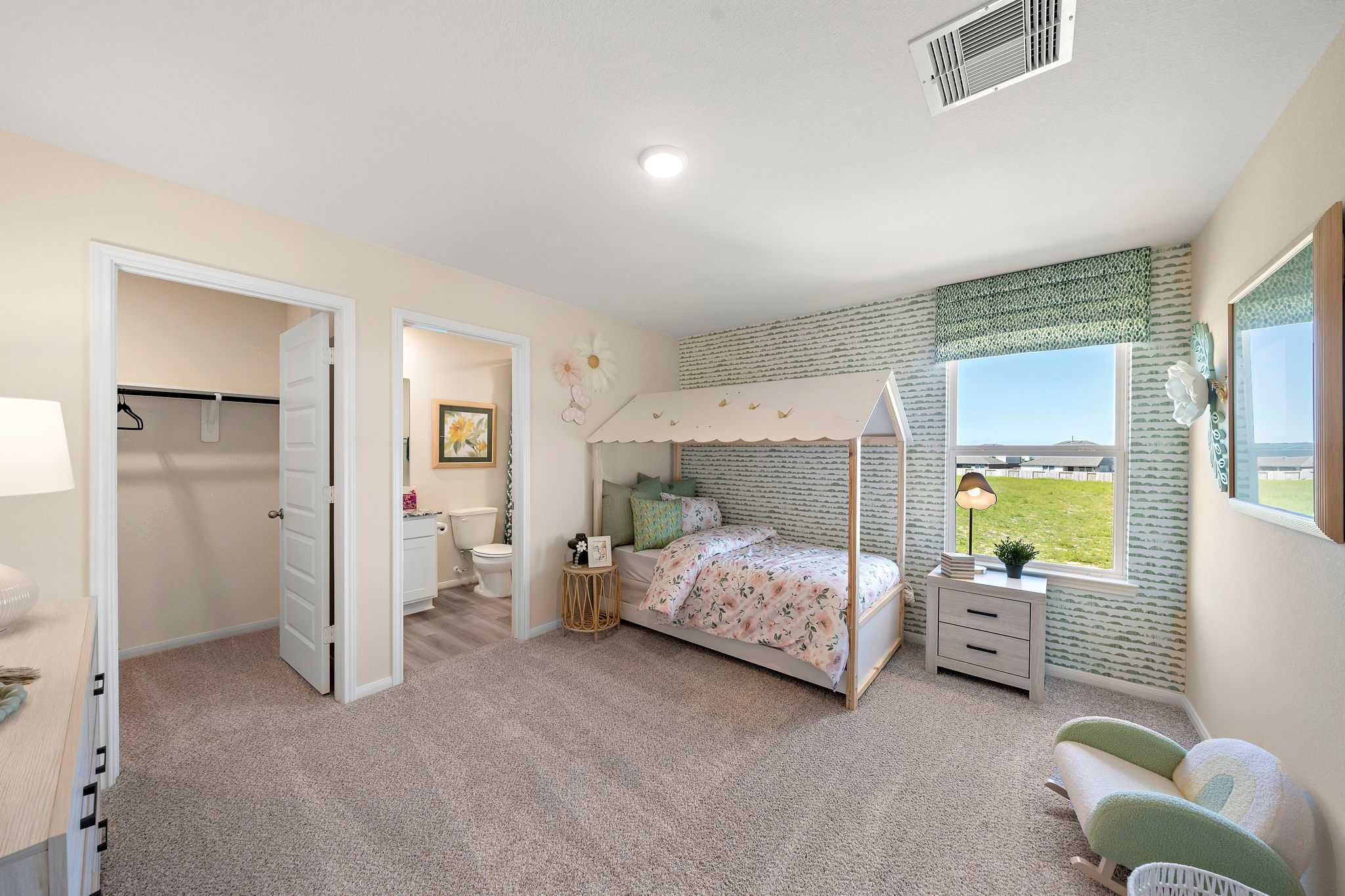 Charming girl's bedroom at River Ranch Meadows in Dayton Texas with white canopy bed, green accent wall and scenic field views