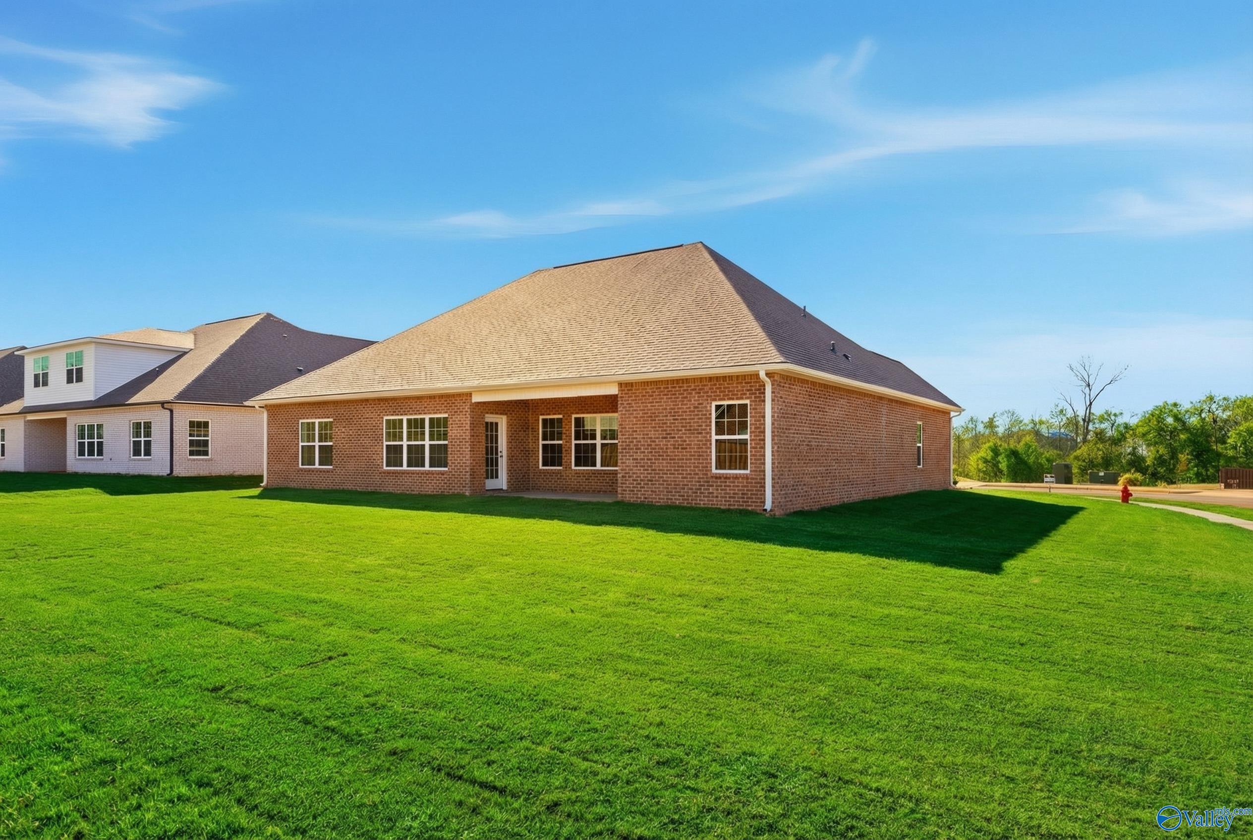 Single-story brick Finleigh home by Davidson Homes in Creekside, Harvest, Alabama, with gabled shingle roof, large windows, and lush green lawn