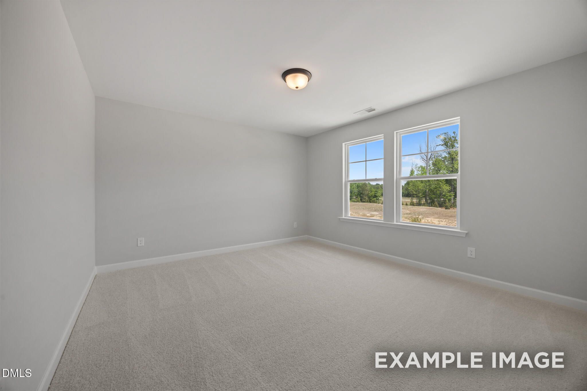Bright empty bedroom with neutral carpet and double windows overlooking scenic views in The Beech floor plan, Wendell Ridge, NC