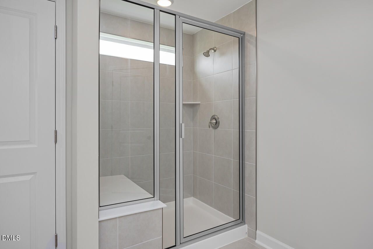Walk-in tiled shower with built-in bench in The Graham floor plan at Springvale, Fuquay-Varina, North Carolina.